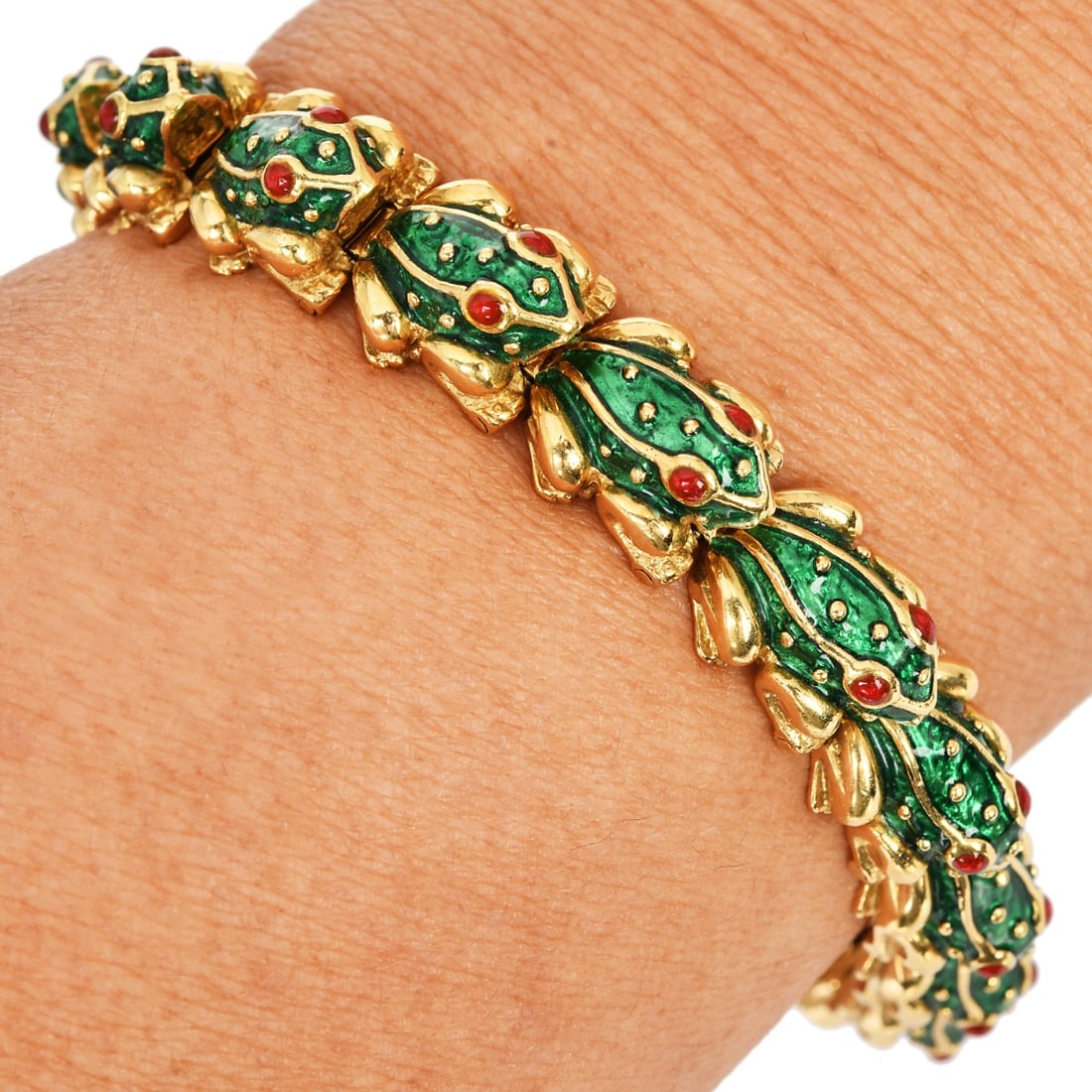 Hidalgo Ruby Eyes Green Enamel Frog 18K Gold Bracelet 54.5 Grams: A whimsical and collectible design, this classic Hidalgo bracelet features a parade of 16 charming frogs crafted in rich 18K yellow gold. Each frog is accented with vibrant green enamel detailing and