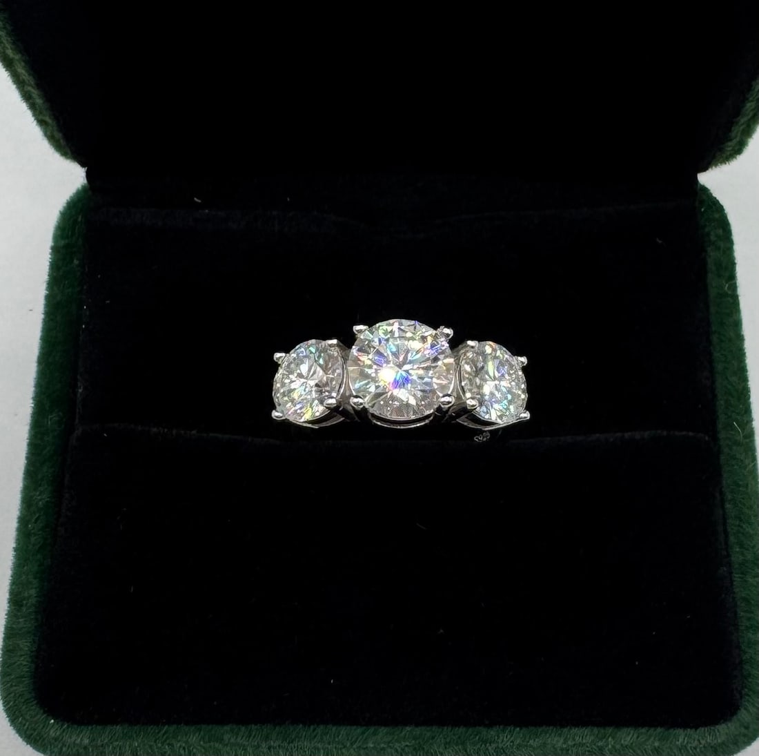Moissanite Ring Mounted in Sterling With White Gold Overlay, COA: 2 Carats middle main Stone And 1 CT each Side Stone Total Of 4 Carats Total. Moissanite Ring Mounted in Sterling with White Gold Overlay, with Certificate Of Authenticity & Jewelry Case. Size: 6