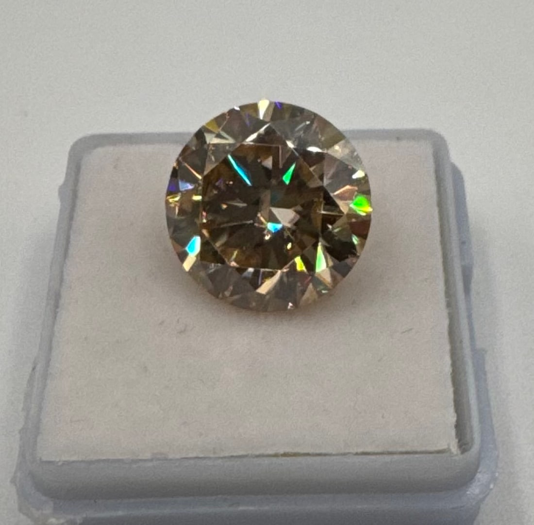 10.00ct Champagne Moissanite Round Brilliant Cut w/ GRA Certificate: Gemstone Type: Moissanite• Weight: 10.00 Carats• Shape/Cut: Round Brilliant• Color: Warm Champagne / Fancy Brownish-Yellow• Certification: Includes GRA (Gemological Research Academ