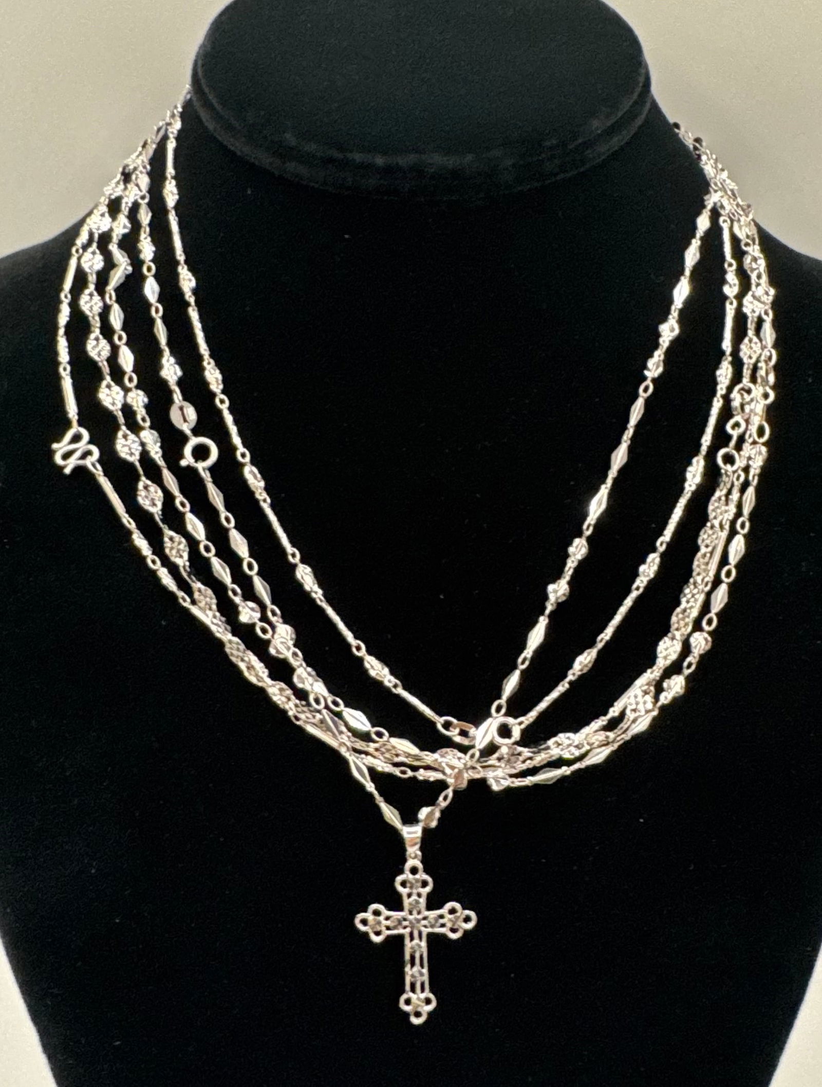 Vintage-Style Multi-Strand Silver-Tone Necklace with Filigree Cross Pendant: A stunning, layered jewelry statement featuring a multi-strand design. This lot includes:• Pendant: A large, ornate filigree Latin cross with intricate openwork and central faceted accents (possi