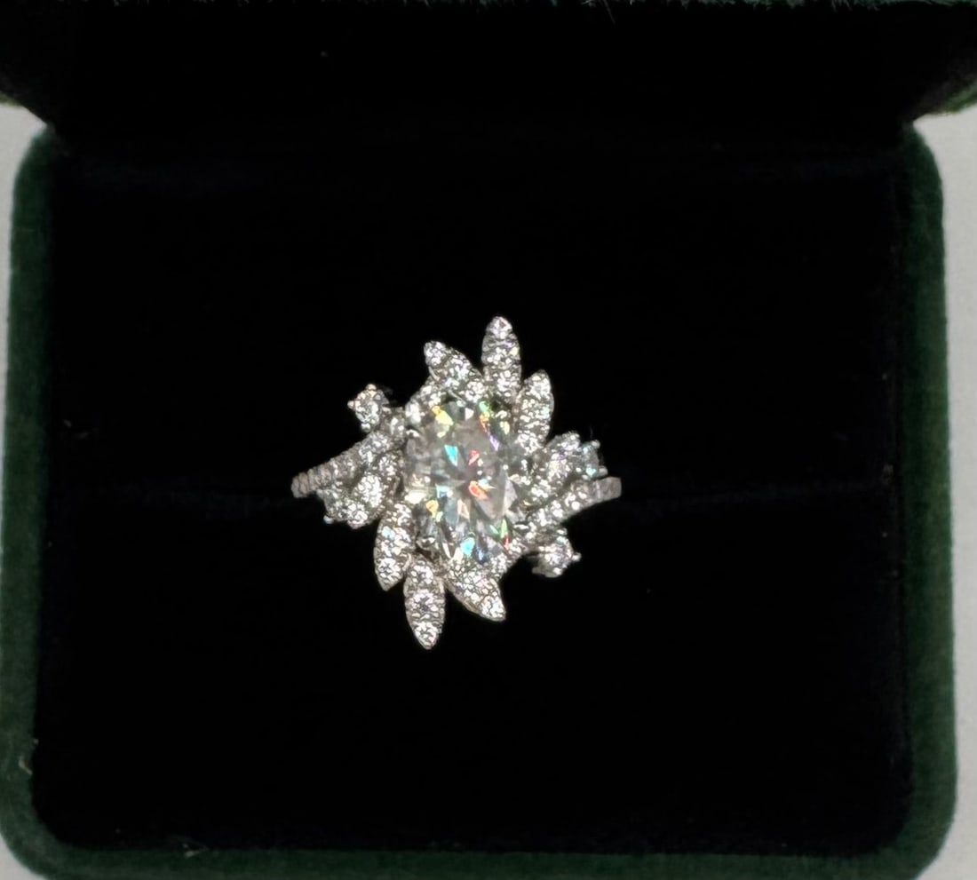 2ct Moissanite Cluster Ring 18k GP Silver GRA Sz 7: A stunning 2-carat Moissanite statement ring featuring a brilliant cluster design reminiscent of a blooming floral starburst. The center stone is accented by a halo of multi-faceted moissanite petals,