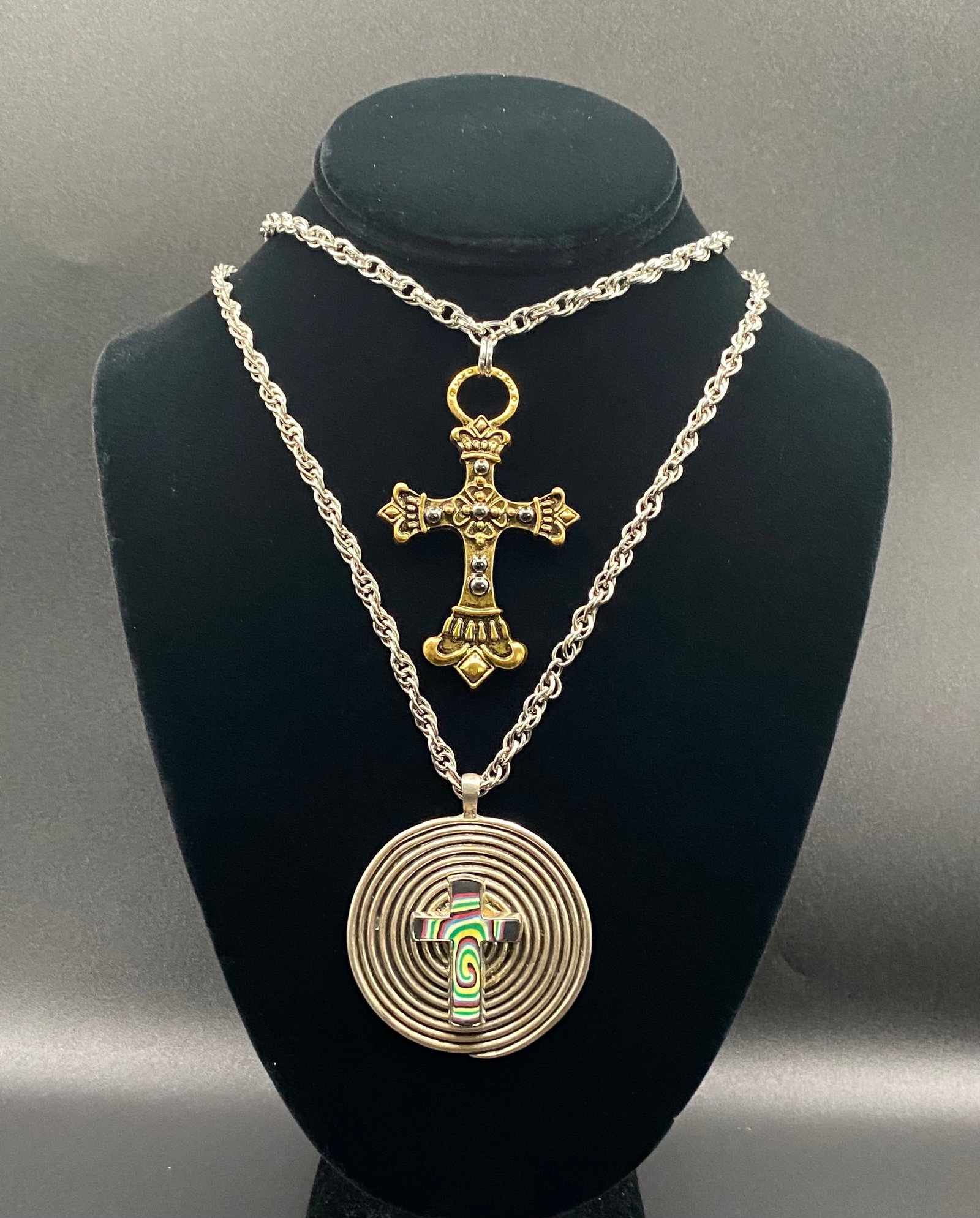 Vintage Religious Jewelry Lot - Ornate Filigree Cross & Modern Spiral Pendant: A diverse pair of religious-inspired necklaces. Includes (1) an ornate, antique-style gold-tone filigree cross on a rope chain and (2) a modern concentric spiral silver-tone pendant featuring a colorf