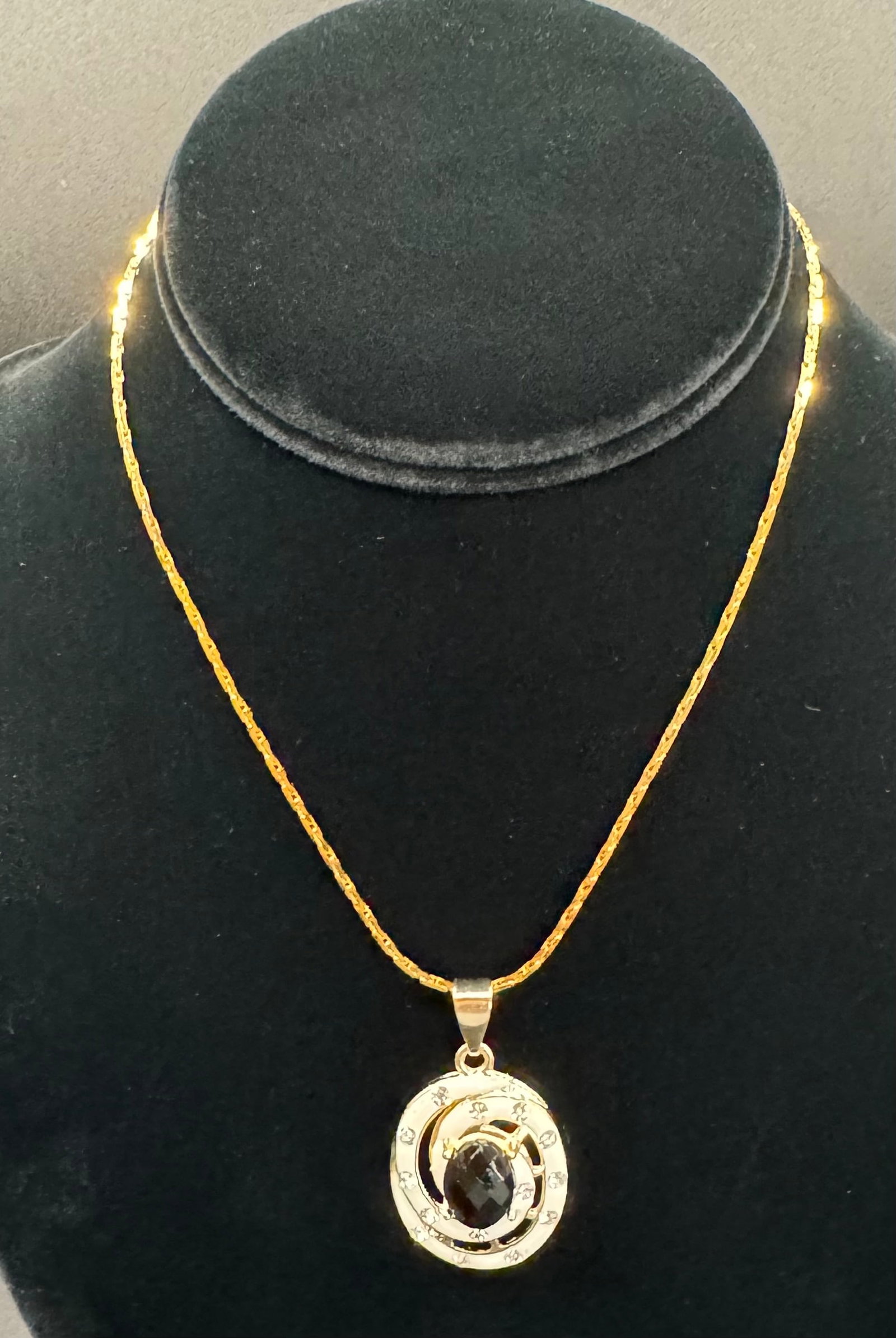 24K Gold HGE Korean Chain & Stylized Swirl Pendant: A sophisticated and modern aesthetic defines this elegant necklace lot. The focal point is a circular pendant featuring a dynamic swirl or "galaxy" motif, centered with a faceted dark gemstone (onyx-t