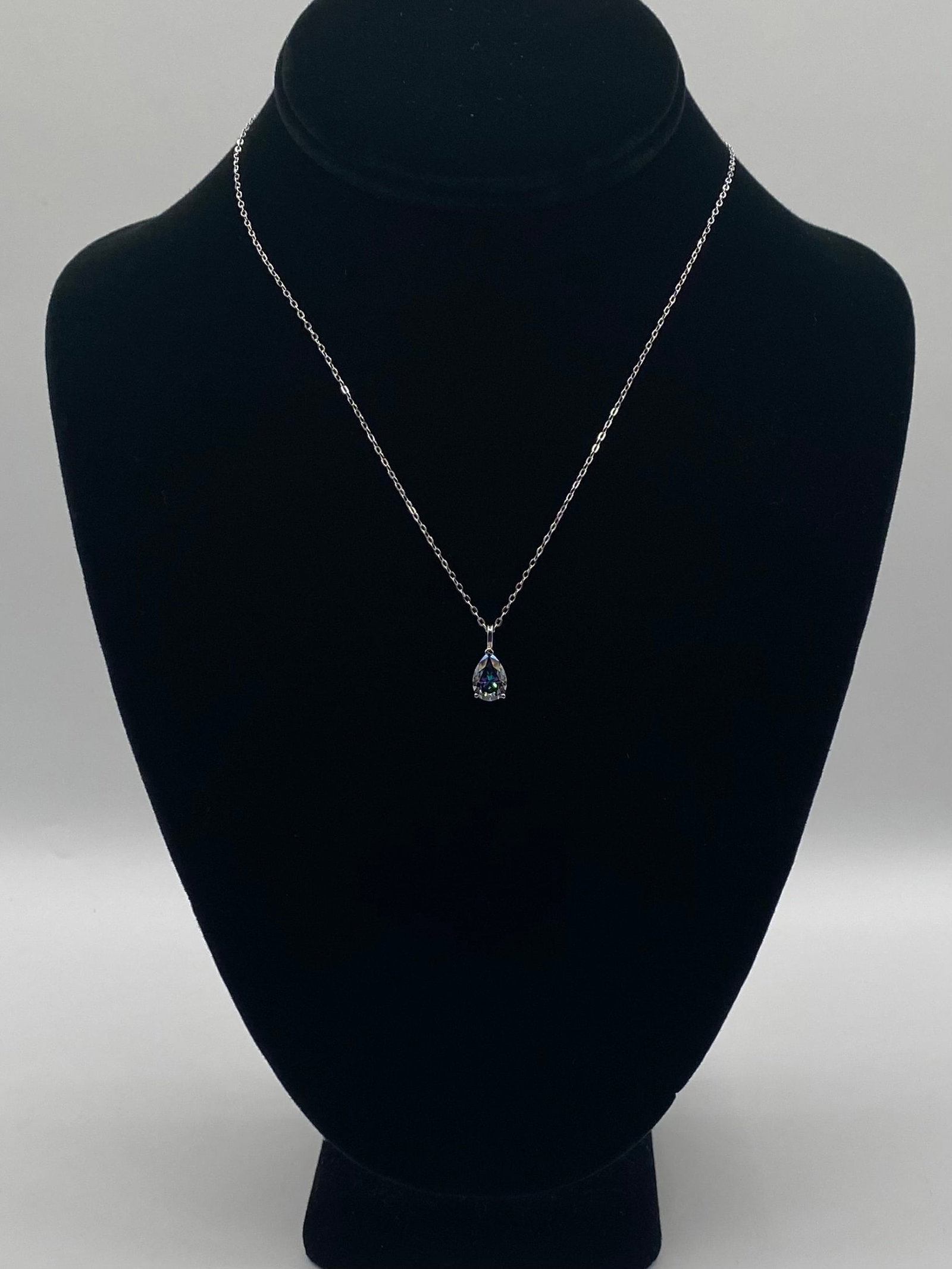 Pear-Cut Rainbow Purple Moissanite Necklace - 18k GP over .925 Silver - GRA Certified: A captivating pear-cut moissanite pendant that showcases a unique iridescent "mystic" color play. This 2-carat stone exhibits exceptional clarity and a rainbow-like luster that shifts with the light. 