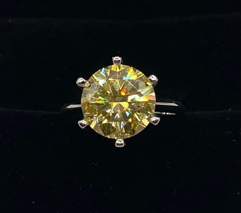 5.00ct Fancy Yellow Round Brilliant Moissanite Solitaire: Capture the allure of a rare canary diamond with this 5.00-carat fancy yellow moissanite ring. The round brilliant cut enhances the deep, warm golden tones of the stone, providing a vibrant and luxuri