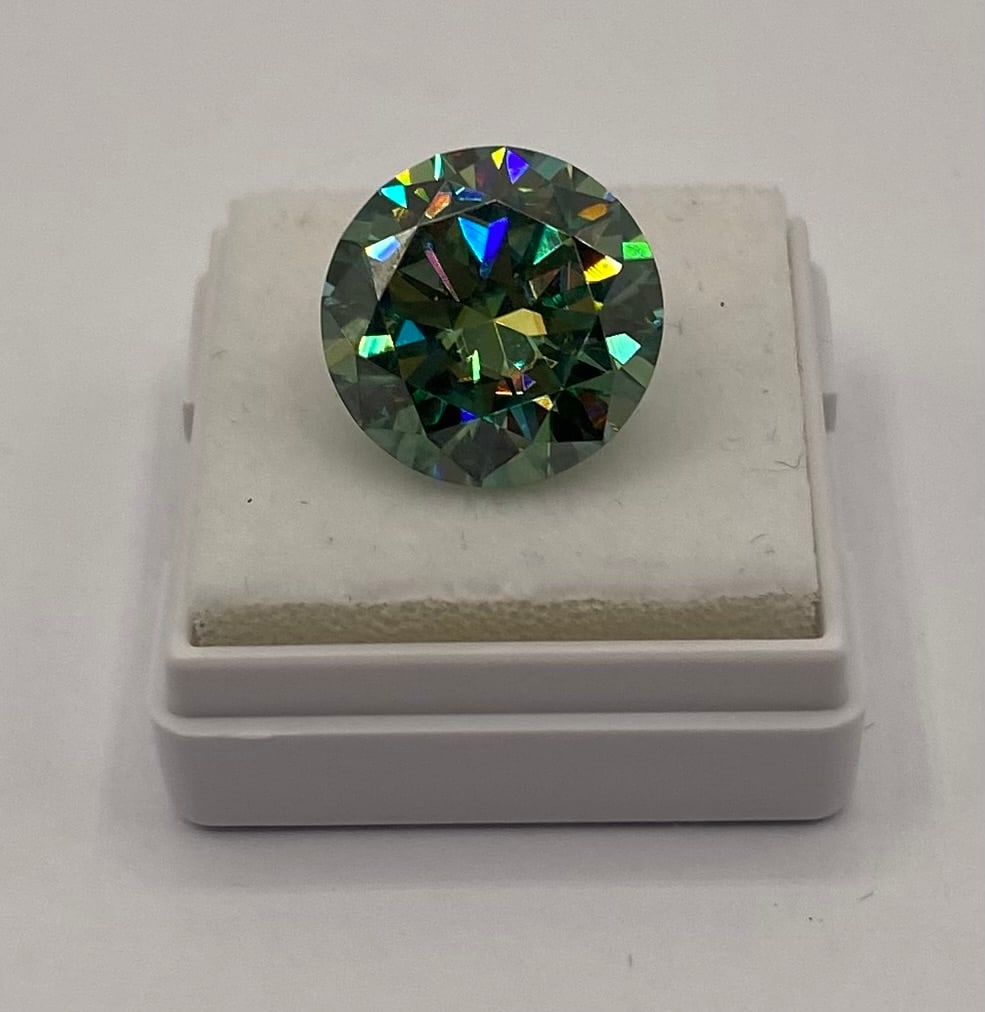 10.00 CT Round Brilliant Cut Blue Green Moissanite - GRA Certified: Weight: 10.00 Carats• Cut: Round Brilliant• Color: Blue Green• Clarity: VVS1 (Eye Clean)• Certification: Includes GRA Certificate and authenticity card.• Testing: Passes