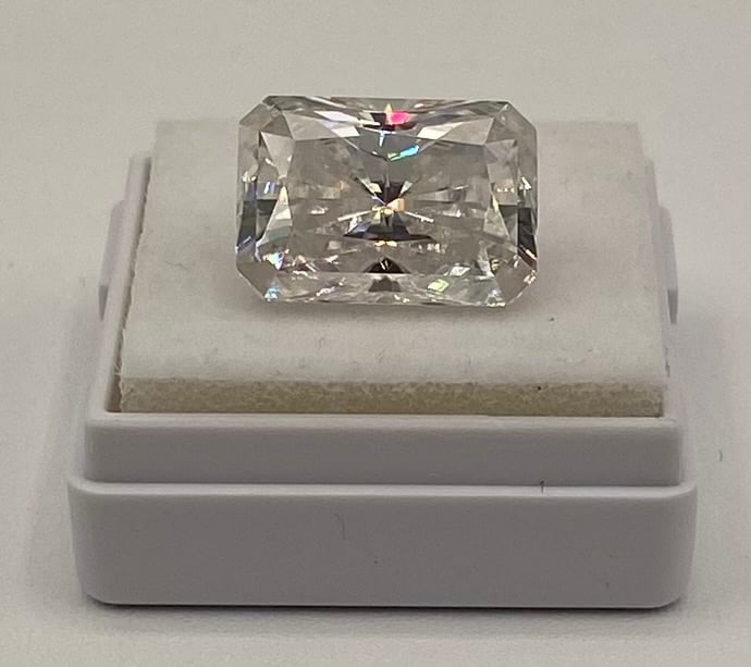 10 Ct Radiant Cut Moissanite Stone - VVS Clarity - Passes Diamond Tester w/ Cert: Up for auction is a stunning, loose 10.00-carat Radiant cut Moissanite gemstone. This stone showcases exceptional fire, brilliance, and a classic rectangular silhouette with elegantly cropped