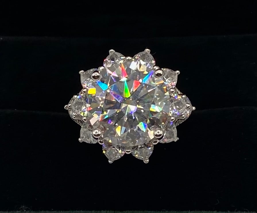 10 CT VVS Moissanite Halo Cluster Ring, 18K White Gold Plated: Center Stone: Moissanite Carat Weight: 10 Carats Clarity: VVS Metal: 18K White Gold Plated over Sterling Silver Ring Size: 8 Testing: Confirmed to pass as diamond on standard thermal diamond testers.