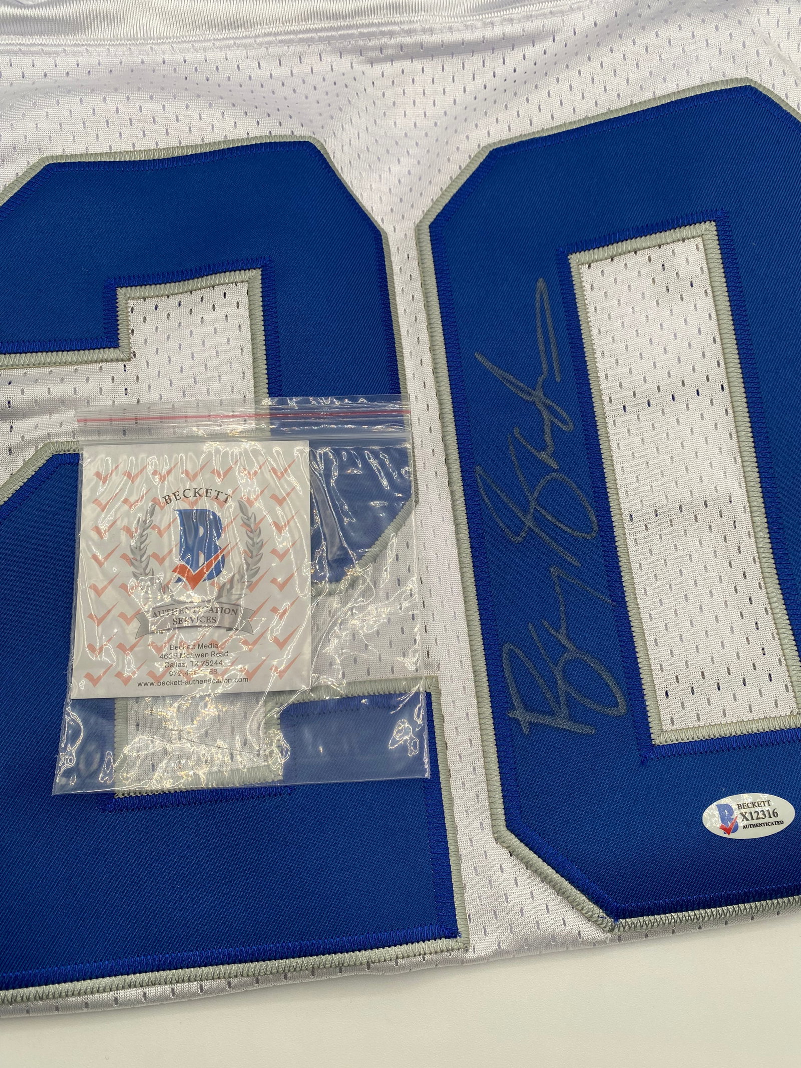 Barry Sanders Signed Detroit Lions Custom Jersey (Beckett COA): Up for auction is a Detroit Lions custom football jersey hand-signed by Hall of Fame running back Barry Sanders. The autograph is crisply signed in silver ink directly on the blue jersey number. This