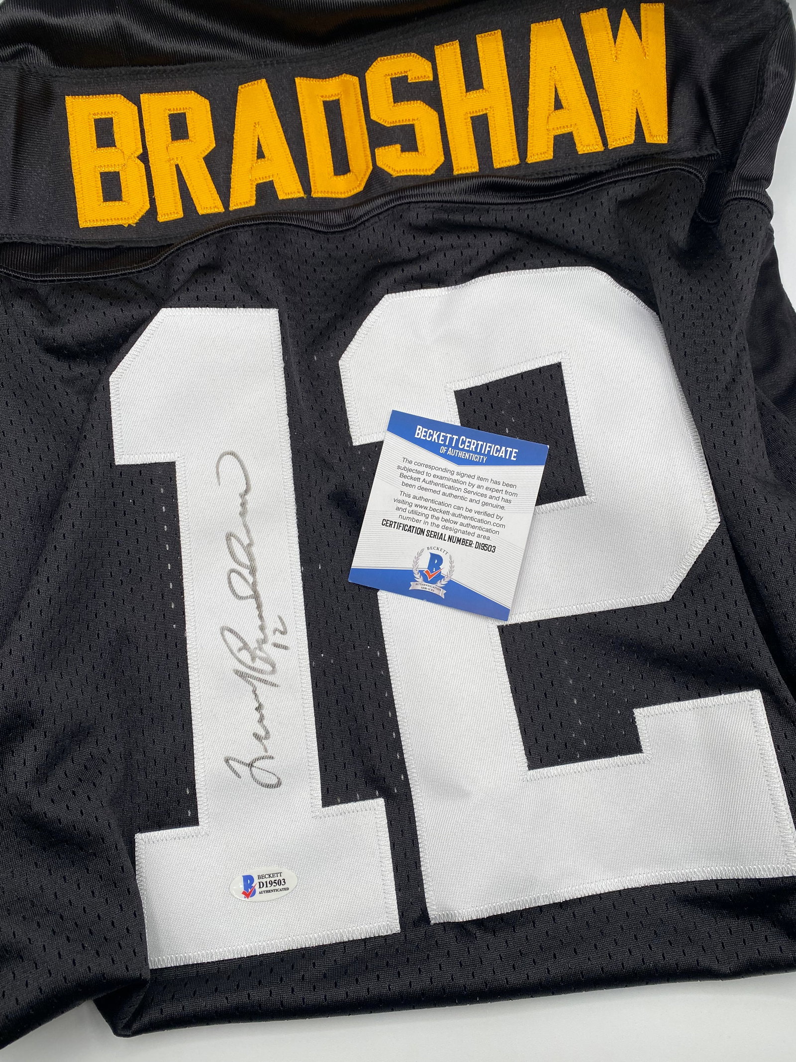 Terry Bradshaw Signed Pittsburgh Steelers Custom Jersey (Beckett COA): A classic piece of gridiron history featuring a black Pittsburgh Steelers custom football jersey signed by 4x Super Bowl champion quarterback Terry Bradshaw. The autograph is written in silver ink
