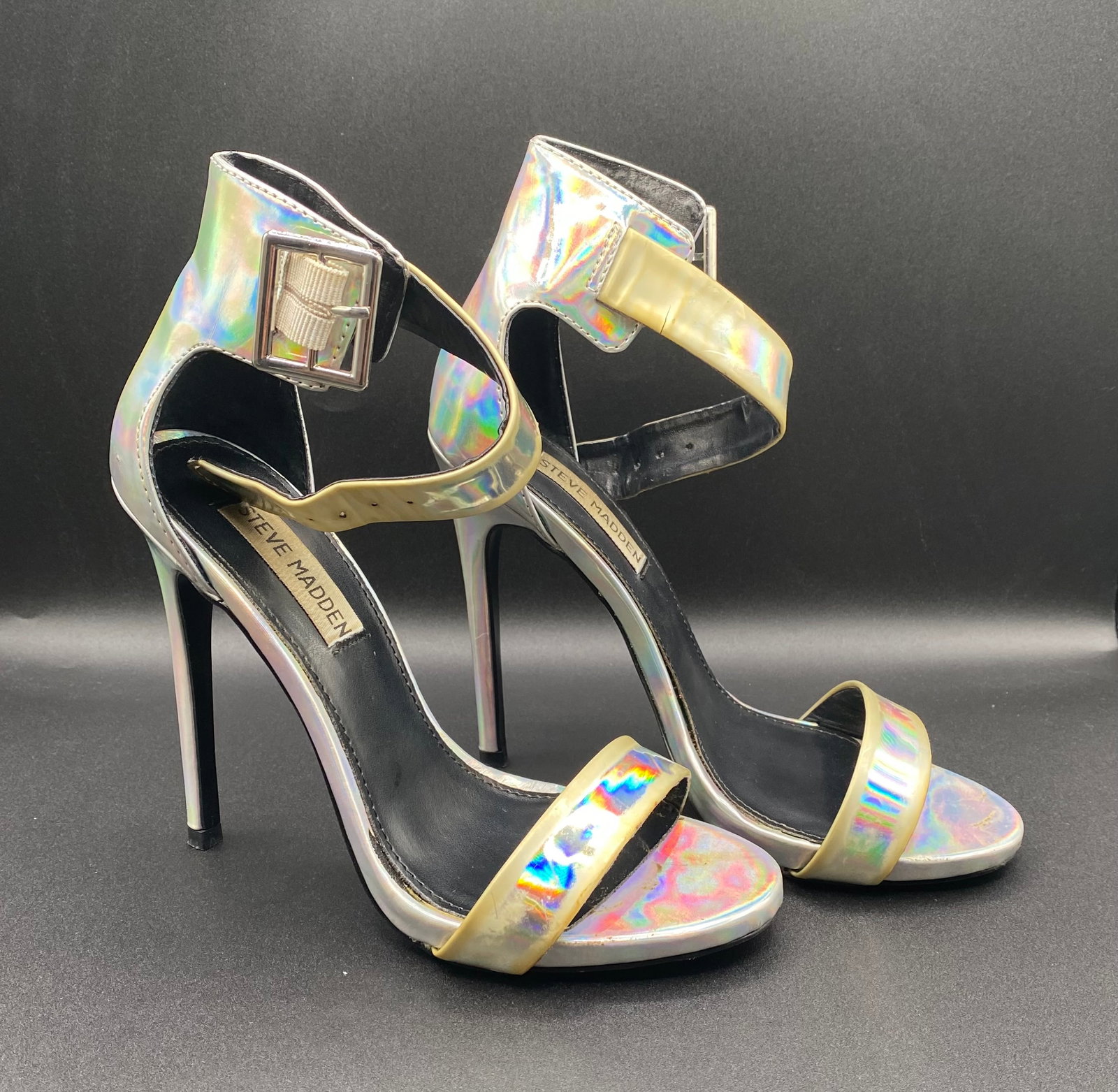 Steve Madden Iridescent Holographic Ankle Strap Stiletto Heels: Up for auction is a statement pair of Steve Madden Holographic Stiletto Heels featuring a metallic iridescent silver finish that shifts color in the light. Built with a open-toe front strap, structure