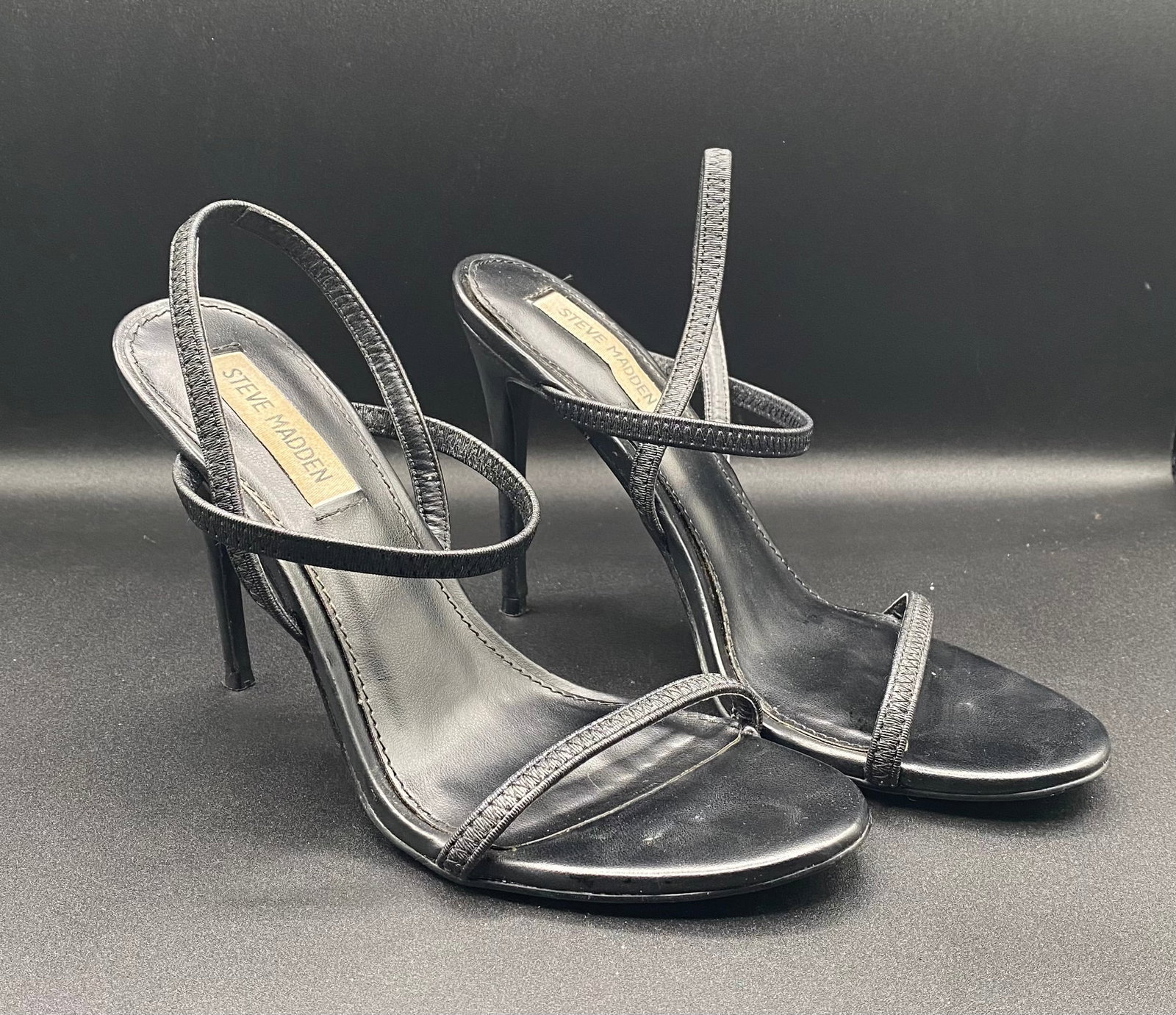 Steve Madden Black Elastic Strappy Slingback Stiletto Heels: Up for auction is a sleek pair of Steve Madden Strappy Stiletto Sandals in classic black. Designed with elasticized strappy vamps, flexible slingback heel straps, open square-round toe footbeds, and h