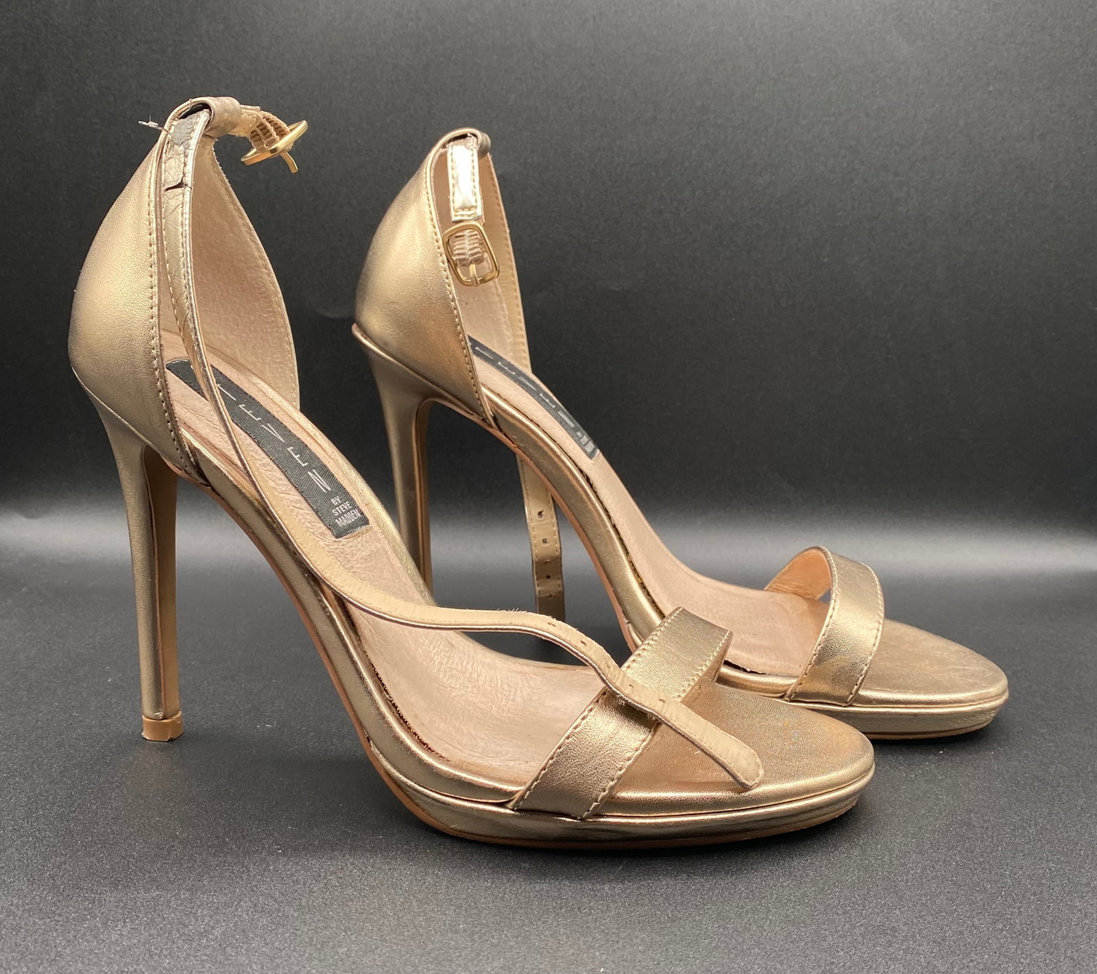 Steven by Steve Madden "Rykie" Gold Metallic Leather Ankle Strap Heels: Up for auction is an elegant pair of Steven by Steve Madden "Rykie" Ankle Strap Stiletto Heels in metallic gold leather. Designed with a delicate toe strap, asymmetrical instep strap, structured heel 
