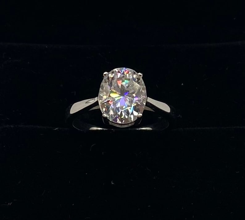 Sparkling Oval Shape VVS Ring: Total Carat Weight: 2.00 Carats Gemstone: Lab-Created Moissanite Stone Color: D (Colorless) Clarity: VVS1 (Virtually Flawless) Metal: 18K Gold Plated over 925 Sterling Silver Ring Size: 8 (US) Testing