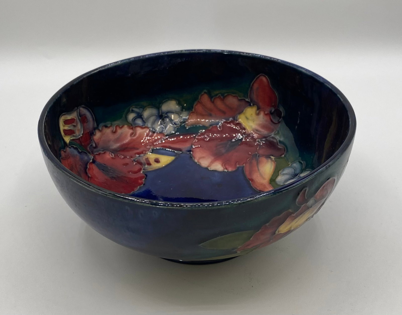 Moorcroft Pottery Orchid Pattern Cobalt Blue Bowl - Signed W. Moorcroft: An exquisite Moorcroft Pottery ceramic bowl featuring the classic tube-lined "Orchid" floral pattern against a rich cobalt blue ground. Maker: Moorcroft Pottery (England) Artist/Signature: Hand-signed