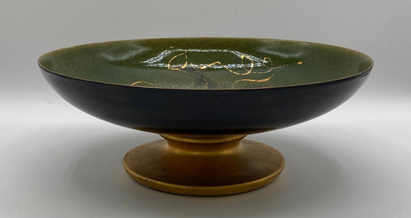 Mid-Century Modern Sascha Brastoff Signed Green & Gold Enamel Pedestal Bowl: An elegant Mid-Century Modern enamel-on-metal/copper compote pedestal bowl by California designer Sascha Brastoff, featuring a abstract green ground decorated with fine gold leaf accents and a gilded 