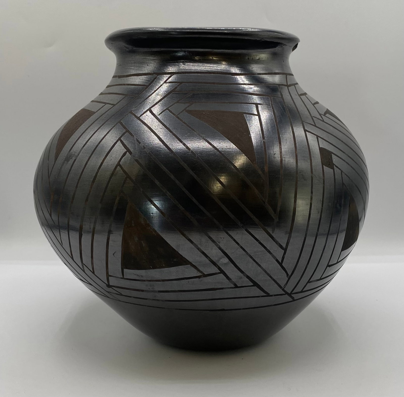 Mario Olivas Mata Ortiz Black-on-Black Geometric Pottery Jar: A hand-coiled, burnished Mexican Mata Ortiz ceramic jar by master potter Mario Olivas, featuring fine geometric sgraffito and matte line work etched across a polished black-on-black ground. Artist: Ma