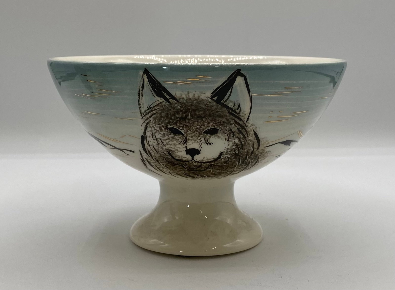 Sascha Brastoff Hand-Painted Ceramic Wolf Bowl: Up for auction is an authentic mid-century modern pedestal compote bowl by California artist Sascha Brastoff. The piece features a hand-painted wolf/husky portrait set against a soft blue gradient bac
