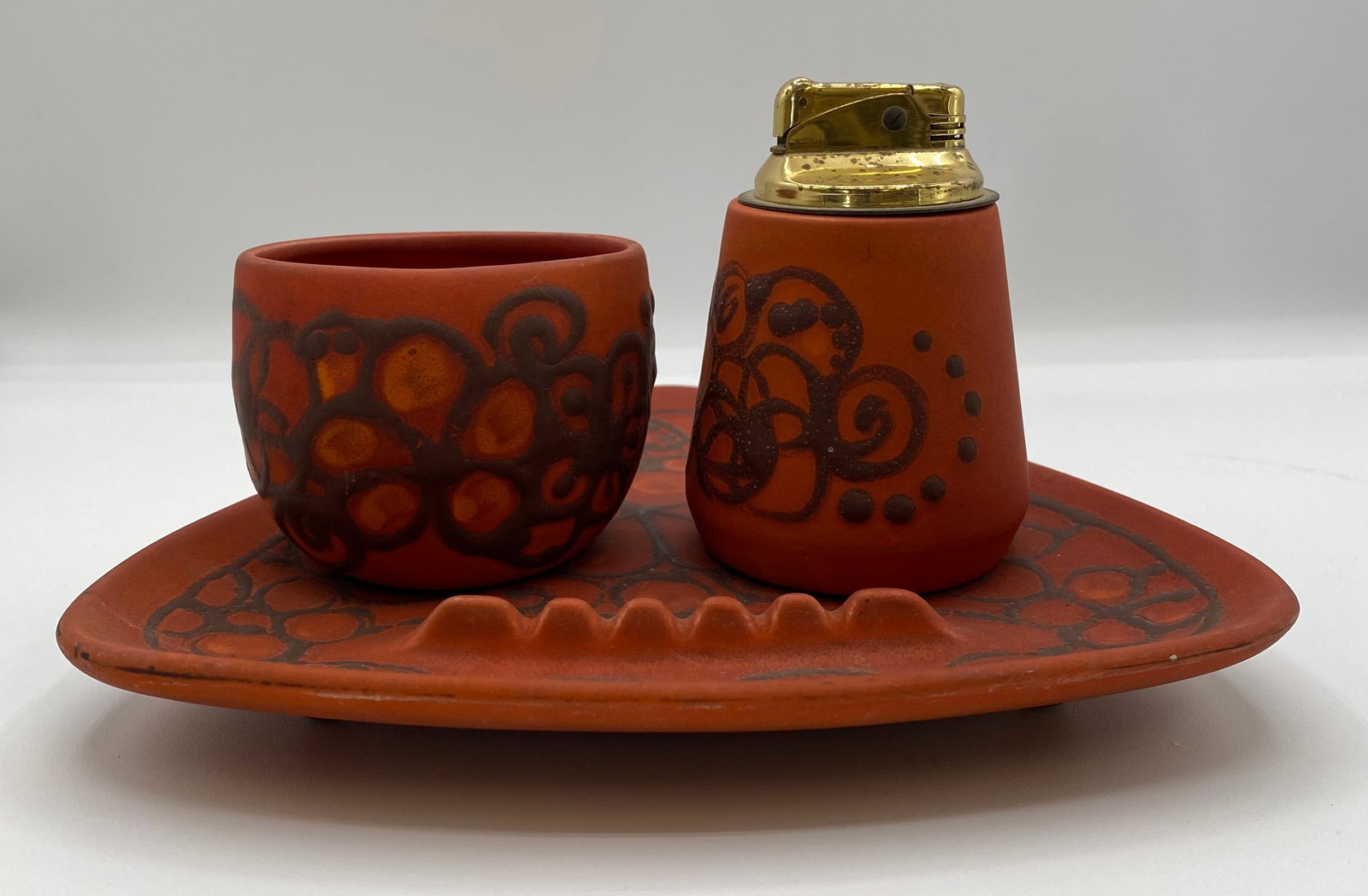Sascha Brastoff Terracotta 3-Piece Lighter, Ashtray & Cup Desk Set: Up for auction is a rare 3-piece mid-century modern smoking desk set designed by famous California artist Sascha Brastoff. Crafted in unglazed terra cotta clay with hand-painted dark brown abstract at