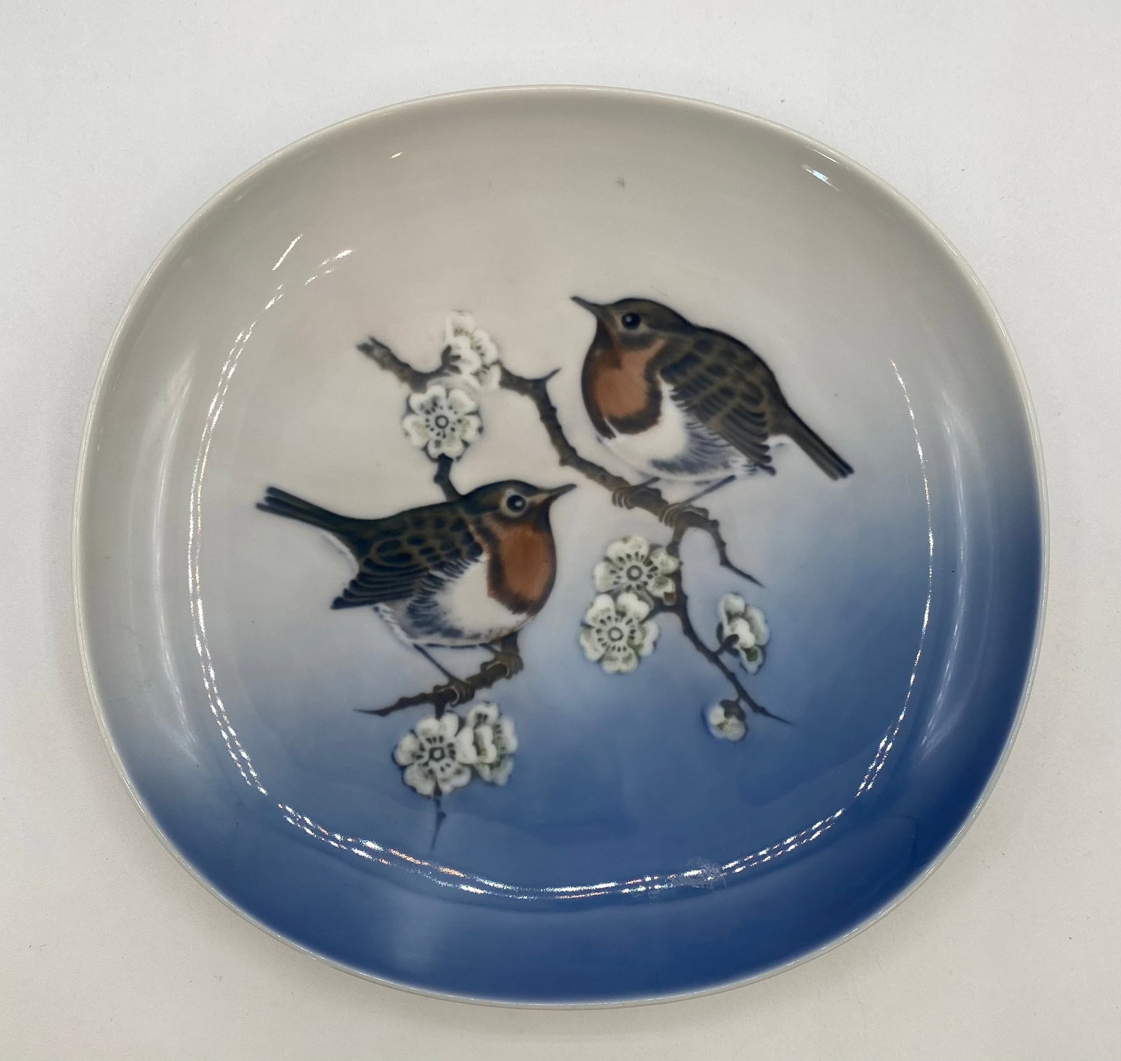 Royal Copenhagen Porcelain Robin Dish "Erithacus Rubecula" #4947: Up for auction is a vintage Royal Copenhagen porcelain cabinet dish or shallow plaque featuring two European Robins (Erithacus Rubecula) perched among flowering cherry branches against a gradient blue