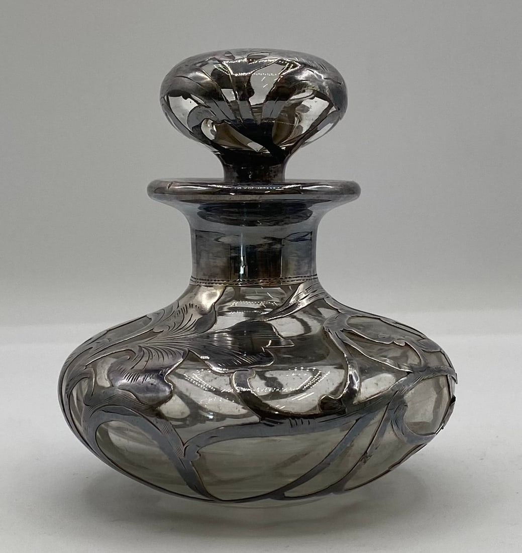 Antique Art Nouveau Sterling Silver Overlay Glass Perfume Decanter Bottle: Up for auction is a fine antique Art Nouveau blown glass perfume decanter bottle featuring intricate sterling / fine silver overlay floral scrollwork. Built in a squat bulbous form with a matching sil