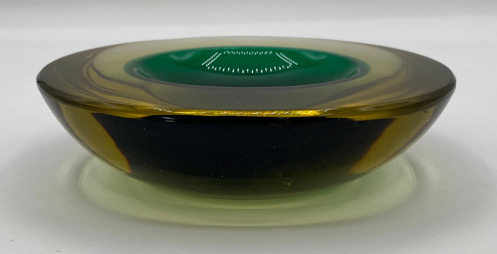 Mid-Century Italian Murano Sommerso Art Glass Ashtray / Vide-Poche Bowl: Up for auction is a heavy mid-century modern Italian Murano sommerso art glass ashtray / bowl. Features a thick, rounded clear amber-yellow outer glass layer casing a deep emerald green interior well,