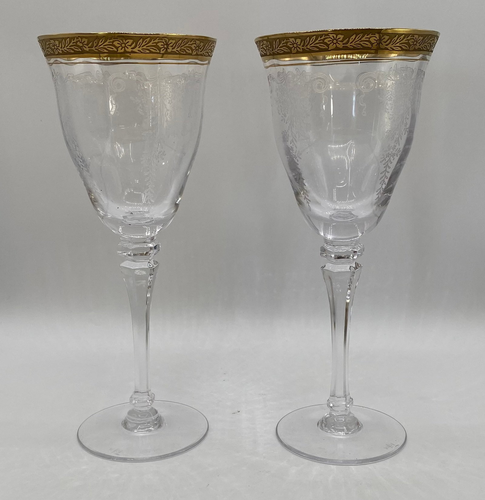 Pair of Vintage Gold Encrusted Rim Etched Crystal Water Goblets: Pair of fine vintage crystal water/wine goblets standing 9 inches tall. Features a wide, heavy gold encrusted rim with detailed floral scrollwork, an acid-etched/needle-etched floral ribbon drape body