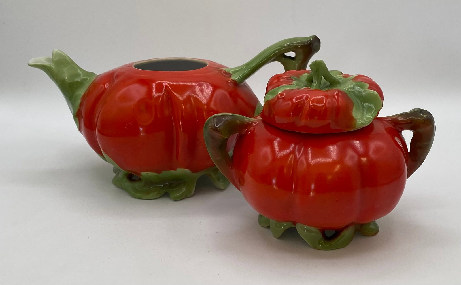 Vintage Royal Bayreuth Bavaria Porcelain Tomato Teapot & Covered Sugar Bowl Set: Vintage fine porcelain tea set shaped like ripe red tomatoes with leafy green spouts, handles, and vine bases. Includes a teapot (7.5 x 4 inches) and a matching double-handled covered sugar bowl (4 x 