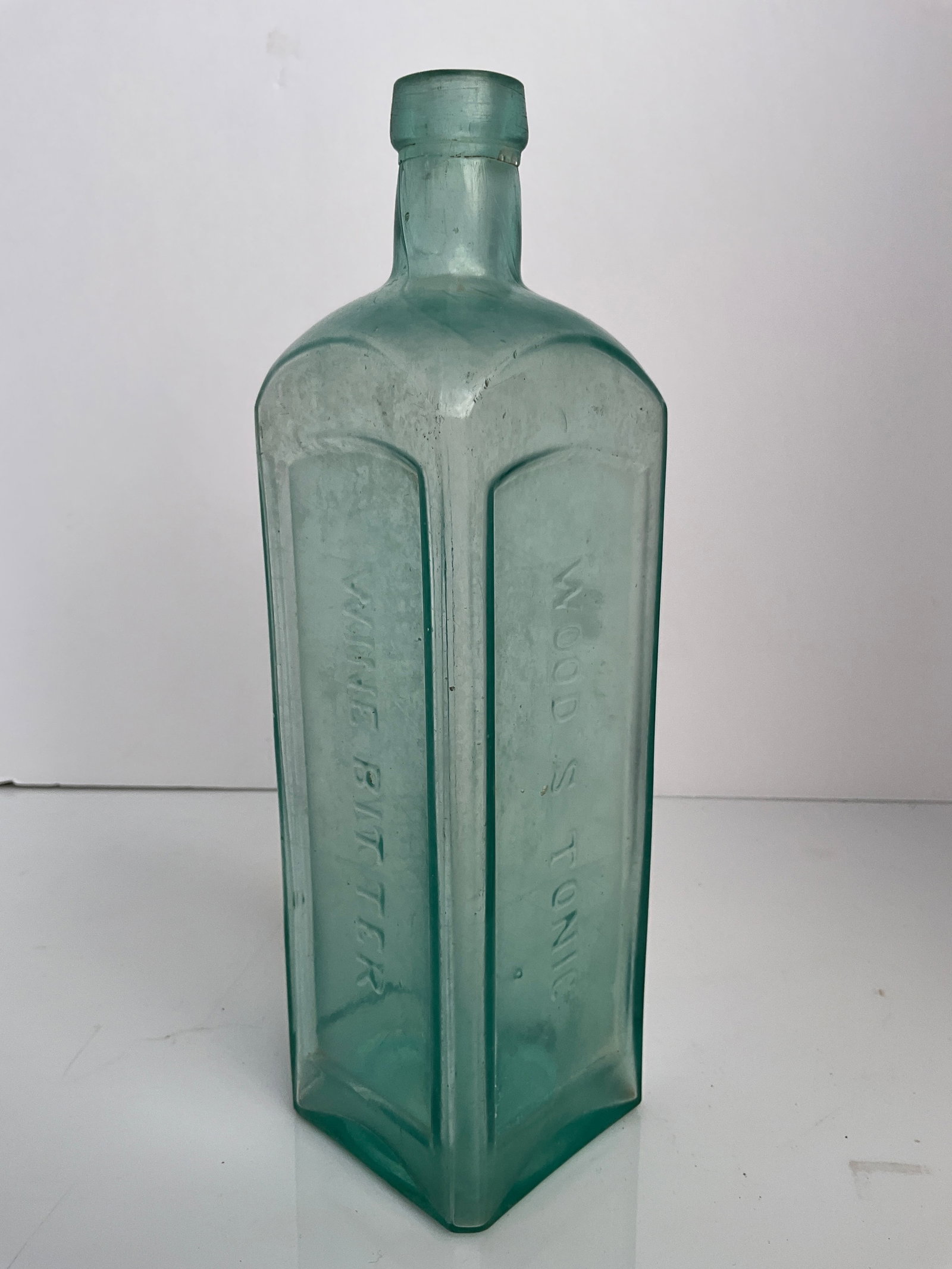 Woods Tonic Wine Bitters, Cincinnati Ohio Paneled Aqua Bottle: Woods Tonic Wine Bitters bottle, Cincinnati Ohio. This bottle has been dug and will need cleaning. It is a heavy bottle that is aqua in color. Two flea bites are located on the bottom of the lip where