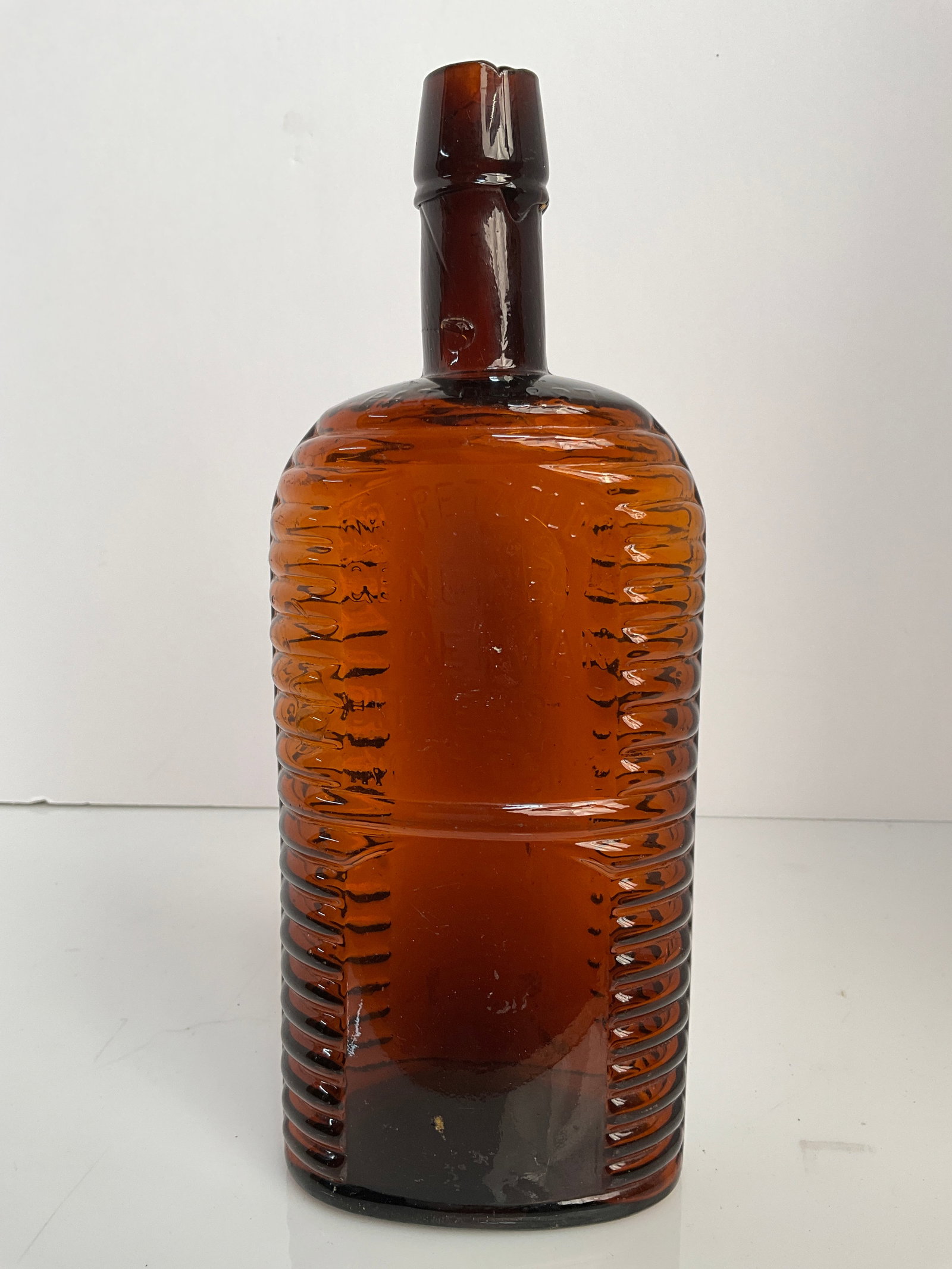 Dr. Petzolds Genuine German Bitters INCPT. 1862, Pat’d 1887: Dr. Petzolds Genuine German Bitters bottle. This bottle is embossed around the top plate of the neck. It is embossed Pat’d 1887. This is a beautiful amber colored bitters bottle that would enhance a