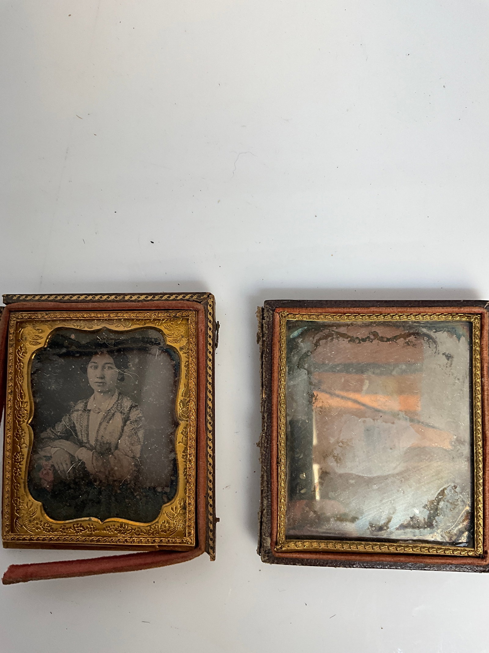 1850s Daguerreotype photo portrait of a woman and an image of a baby: Here is two 1850s Daguerreotype photos. The first is an image of an early dressed woman. The second is the image of a baby. The baby appears to have scratches on it, but the woman has no visible scrat