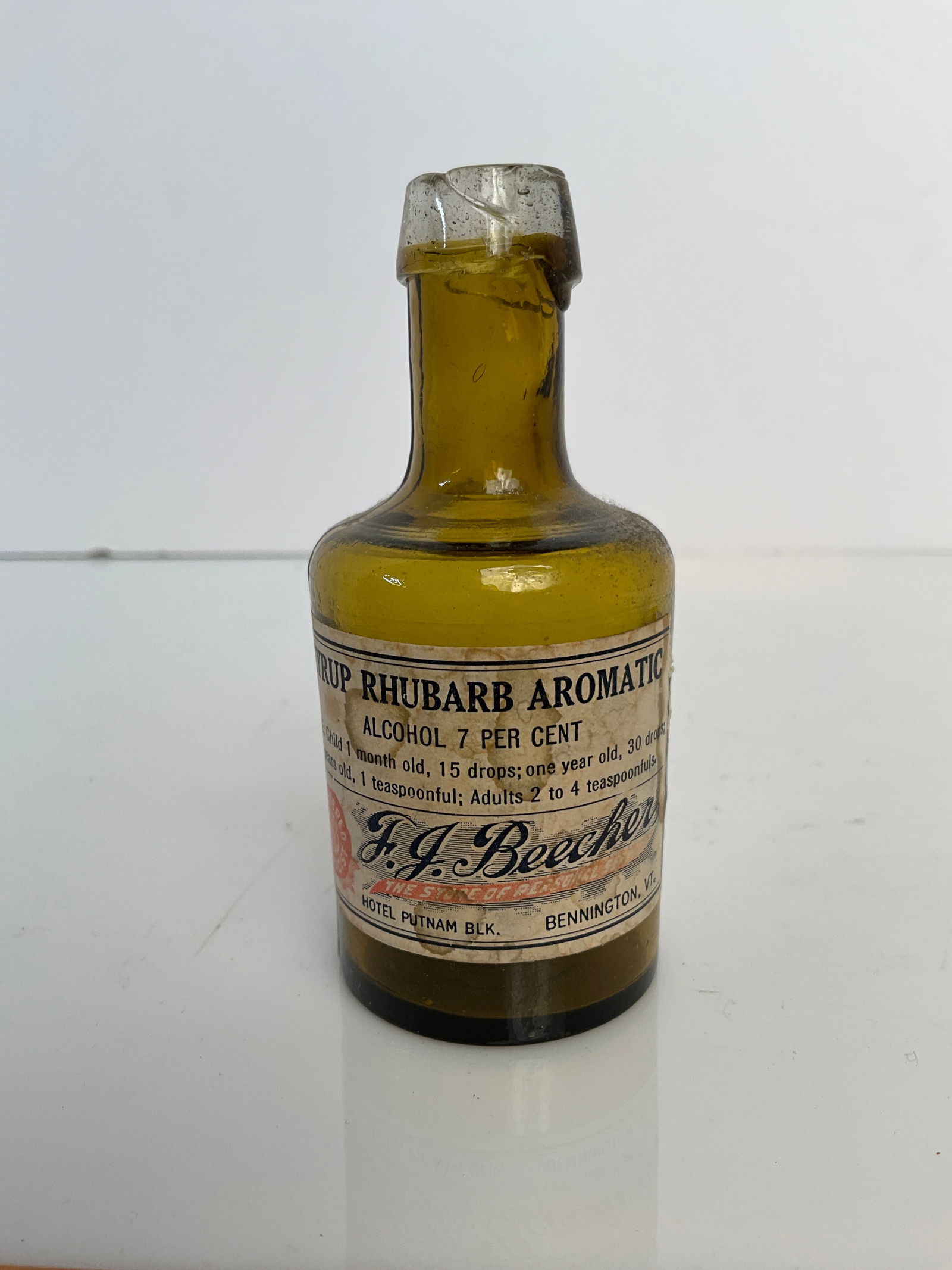 Open Pontiled Amber medicinal bottle, lip is a clear applied glass while the bottle is Amber: Open pontiled medicinal bottle. With a married on label. The owner states that this little medicinal pontiled bottle is stoddard glass. no damage label appears to be newer than the bottle but it's fro