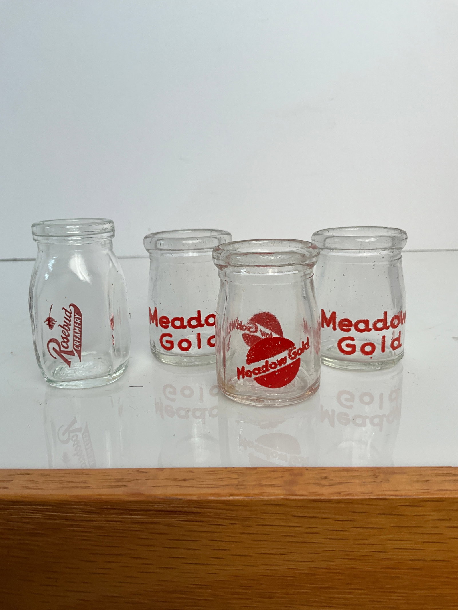 Four milk creamers, three meadow gold, one rosebud creamery: A lot of four milk creamers, three are metal gold, and one from Rosebud creamery no damage.