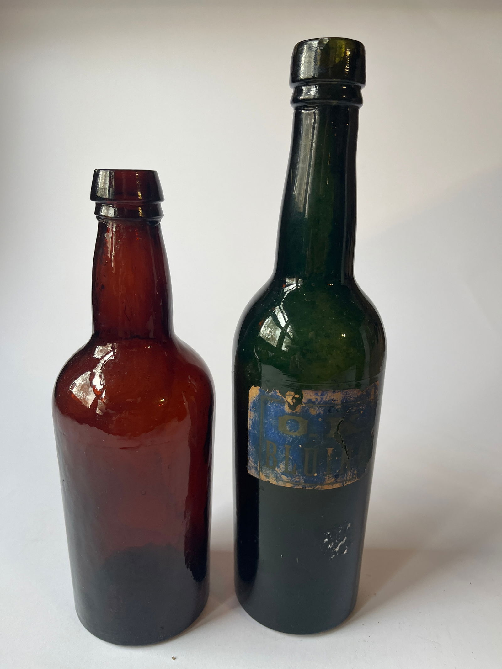 Lot of 2 early colored bottles. One with label. (1 of 4)