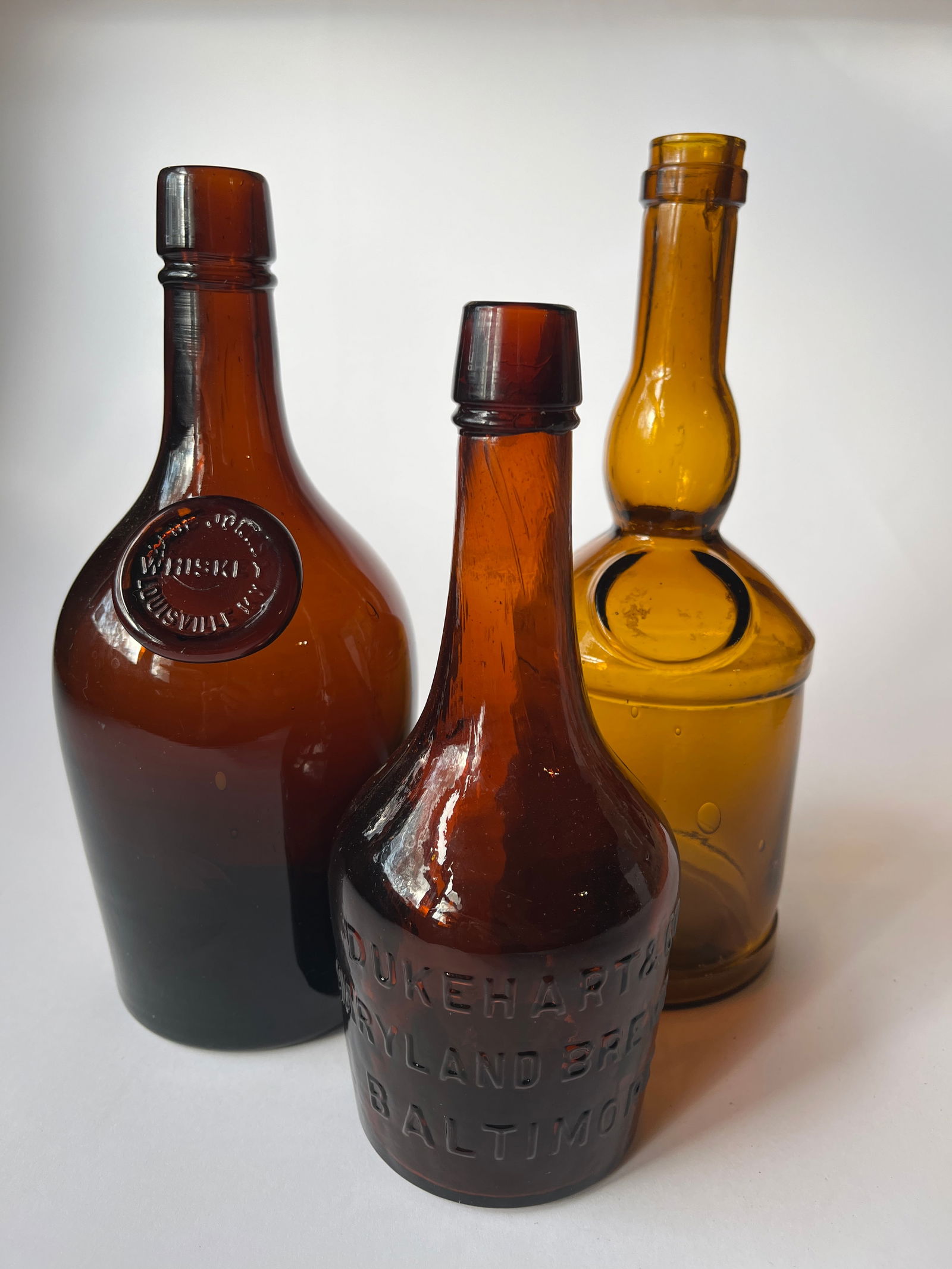 Lot of 3 amber liqour bottles. 2 embossed. (1 of 5)