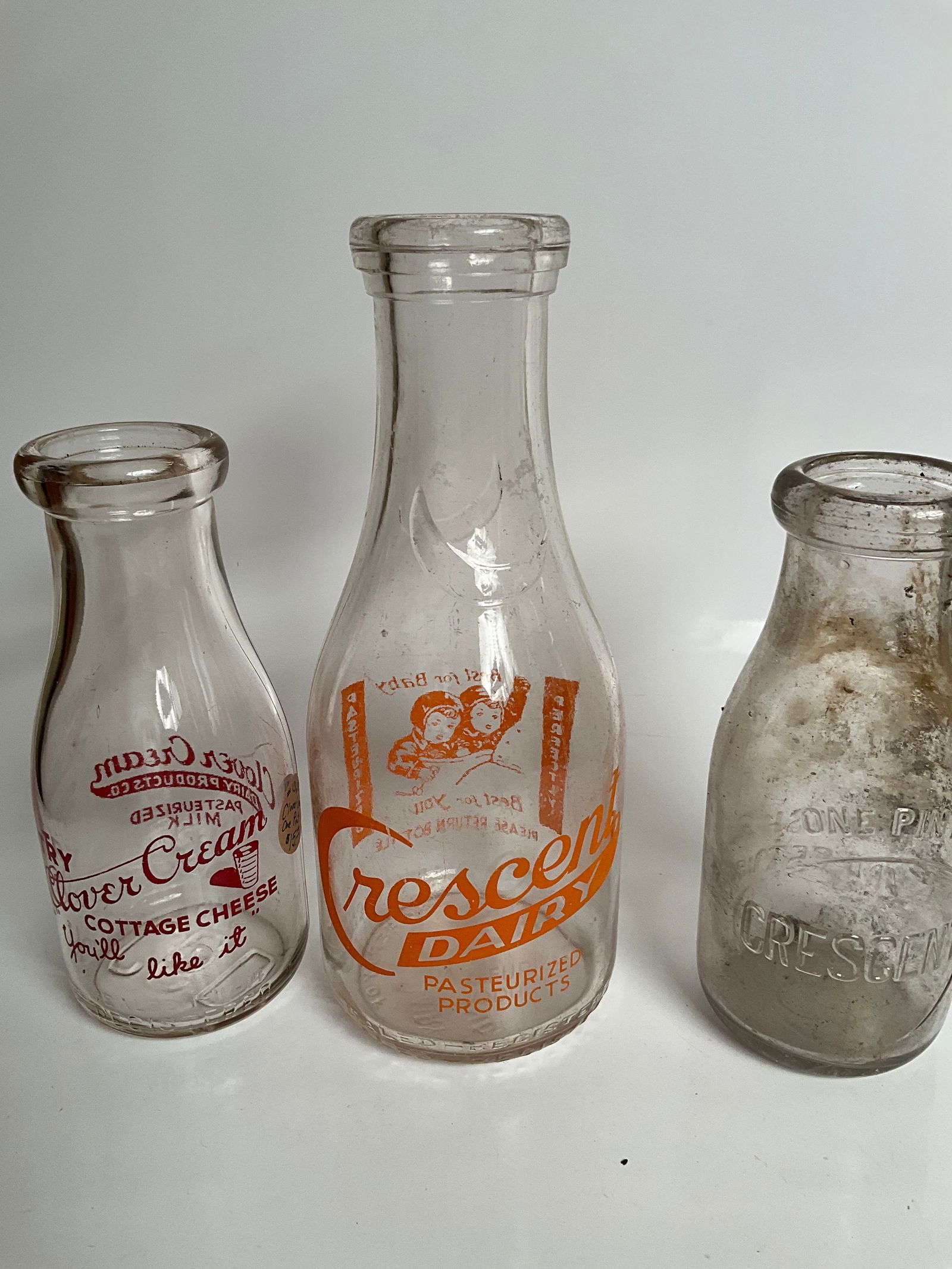 Three milk bottles, two crescent dairy bottles from Kokomo, Indiana, and one clover cream (1 of 5)