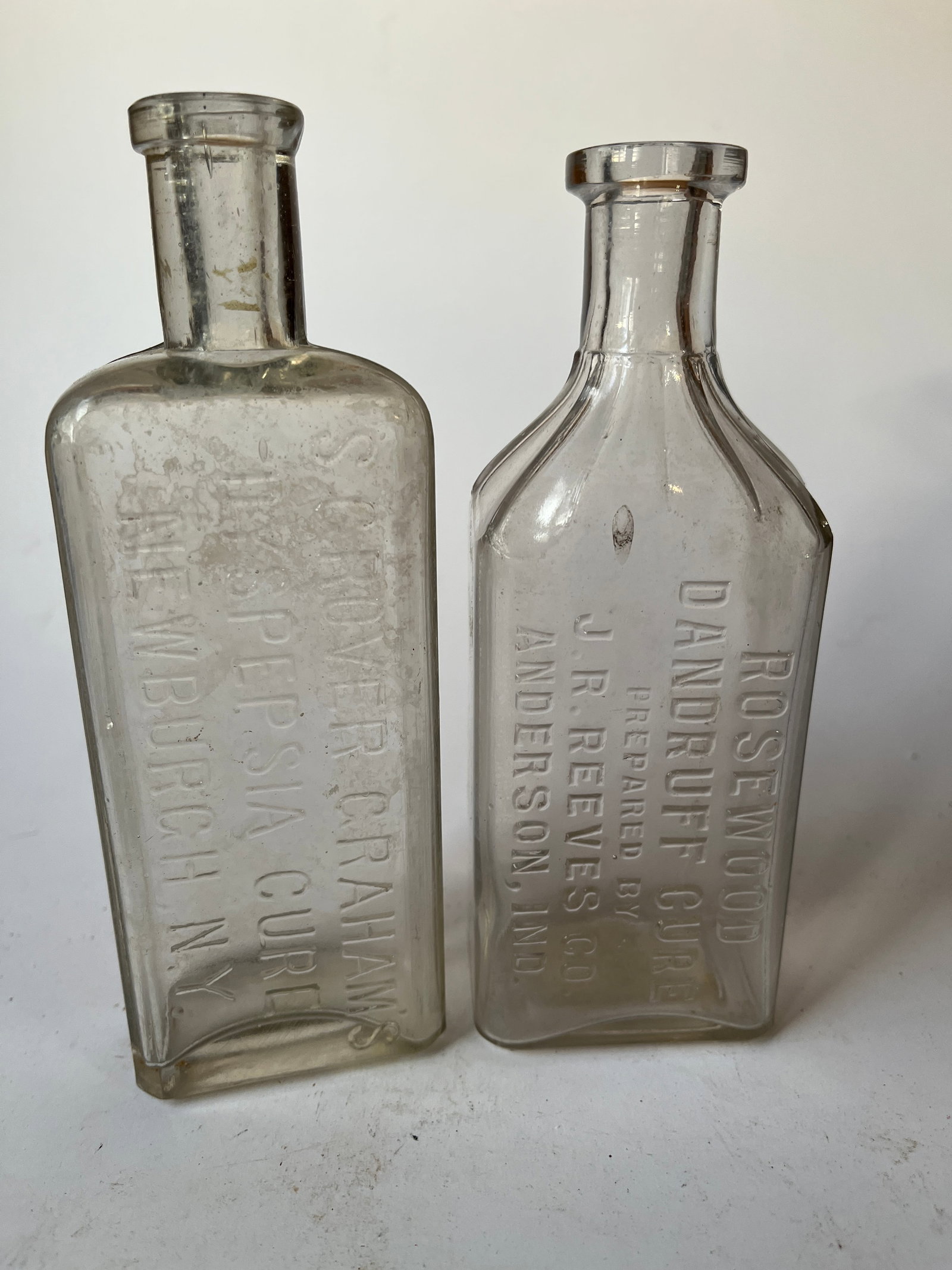 Lot of 2 cure bottles.: Lot of 2 cure bottles. The first is a ROSEWOOD DANDRUFF CURE ANDERSON, IND. The second is a S. GROVER GRAHAM'S DYSPEPSIA CURE NEWBURGH, N.Y. Both bottles are aqua, have light stain but no damage.