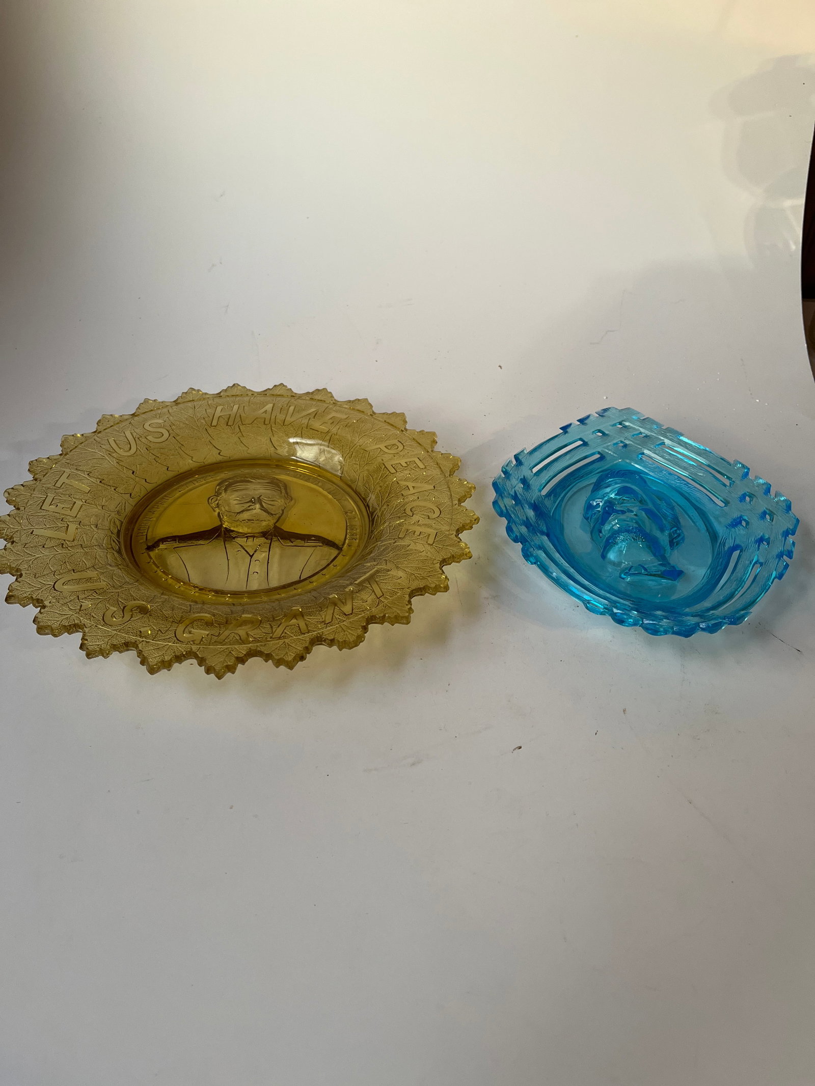 Lot of 2 EAPG presidential plates.: Lot of 2 EAPG presidential plates. The first is blue glass with the bust of Lincoln in high relief in a basket pattern. The second is yellow glass and features U.S. GRANT. It has Grant's dates of birt