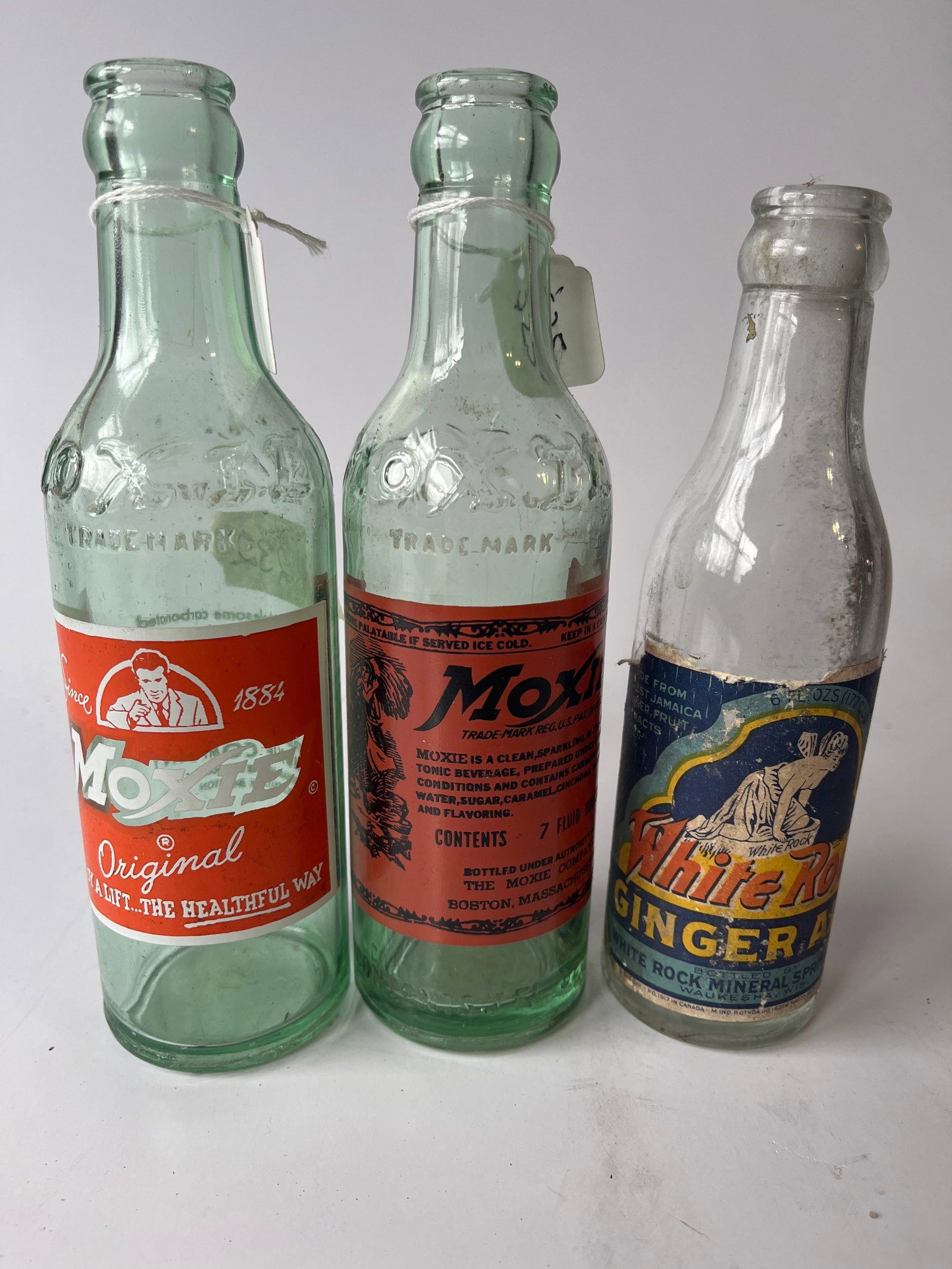 Lot of 3 sodas. 2 Moxies and a White Rose.: Lot of 3 sodas. 2 Moxies and a White Rose. 1 Moxie has a paper label, the other is ACL.Third bottle is also paper label. All no damage.