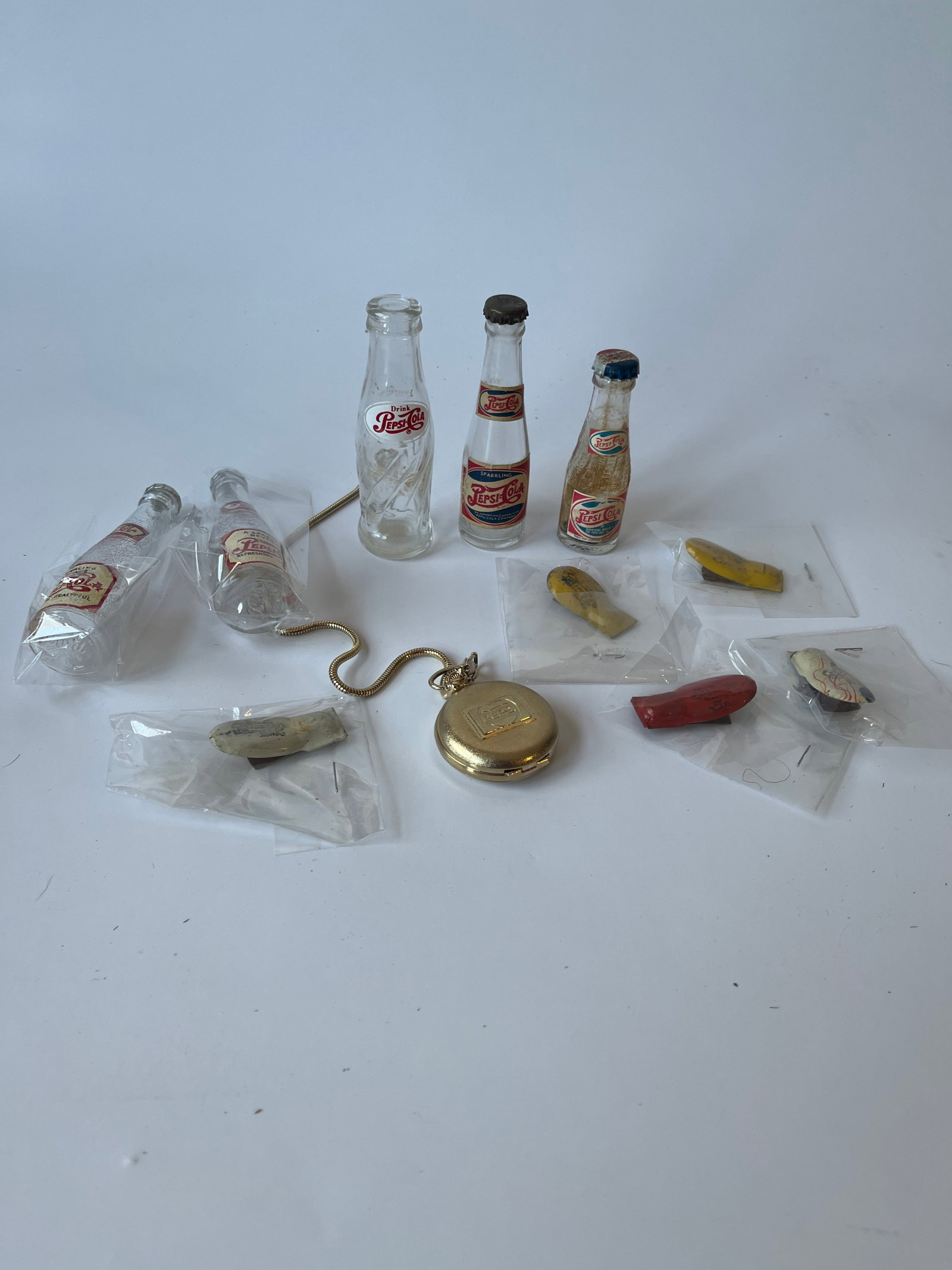Lot of Pepsi collectibles. 3 glass bottles, S & P bottles, 5 clicker and a pocket watch.: Lot of Pepsi collectibles. 3 glass bottles, S & P bottles, 5 clicker and a pocket watch.