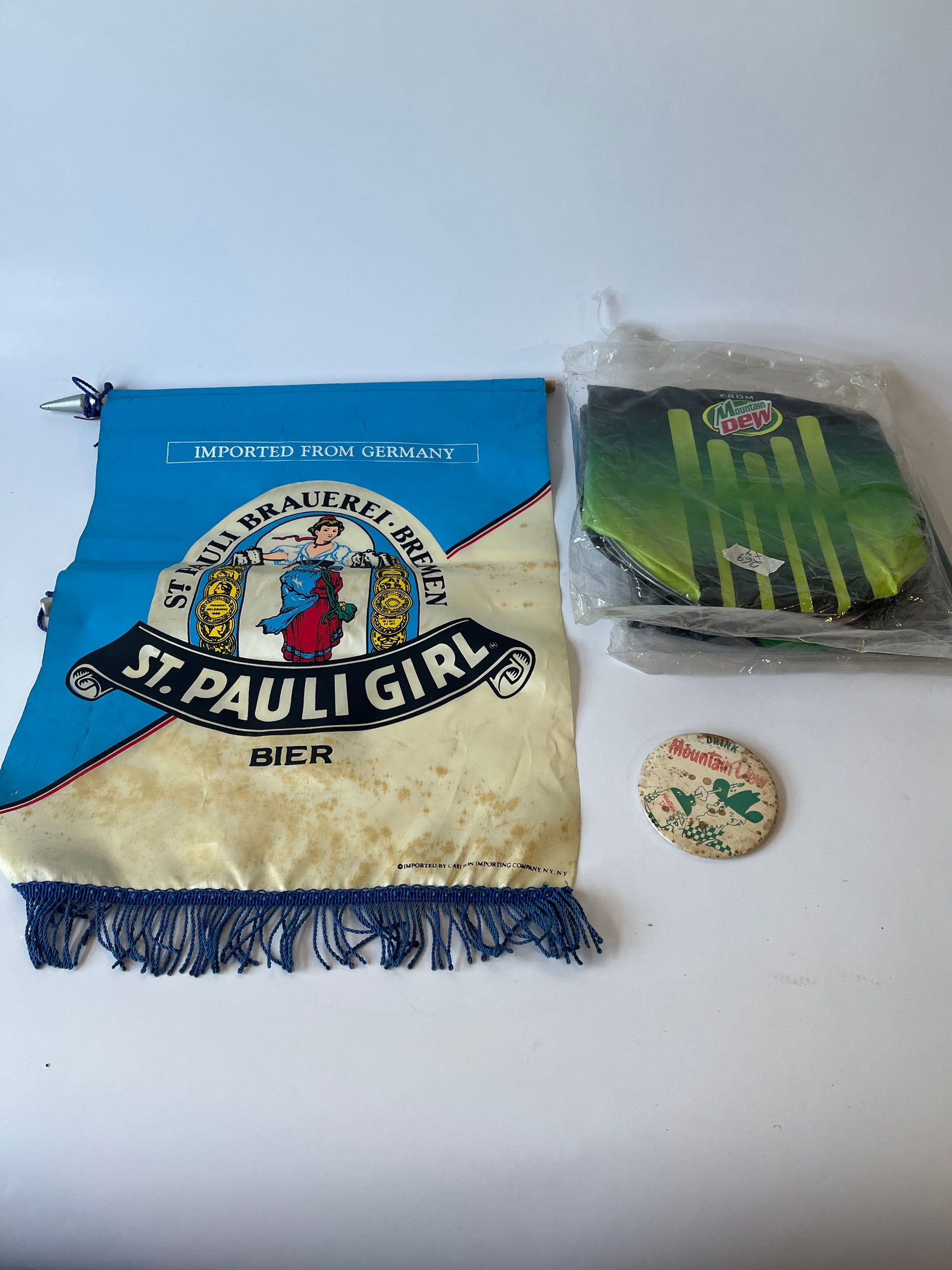 Avertising lot. 1 St. Pauli Beer silk banner, 2 Mountain Dew inflatables & 1 Mountain Dew pinback.: Avertising lot. 1 St. Pauli Beer silk banner, 2 Mountain Dew inflatables & 1 Mountain Dew pinback.