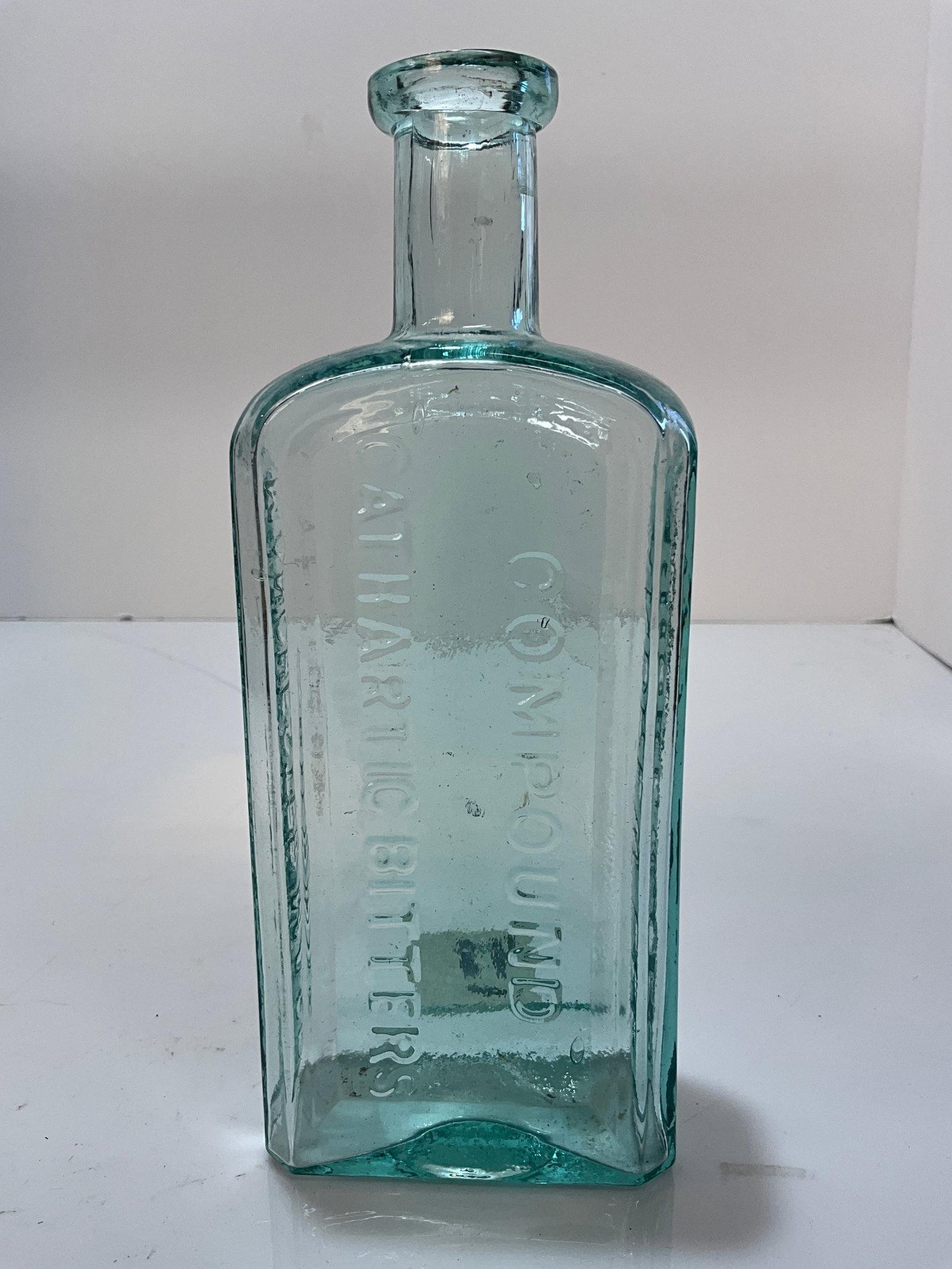 1870's-1880's Andrew Lee Compound Cathartic Bitters, Manchester Mass: 1870's-1880's Andrew Lee Compound Cathartic Bitters, Manchester Mass. Strong embossing. The bottle measures 8" tall. This medicine bottle is aqua in color with four recessed panels, one being left bla