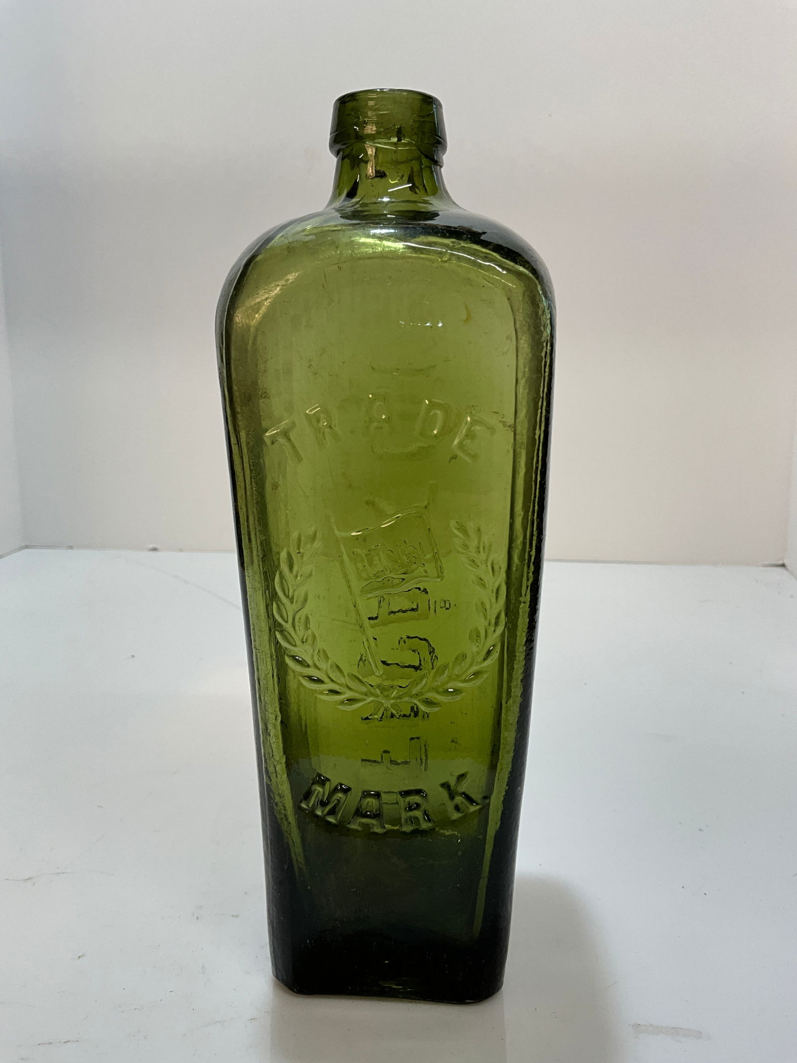 A.T.Co.L. Trade Mark Green GIn Bottle,  W/Wreath and Flag embossed in the middle, African T. Co. L. (1 of 6)