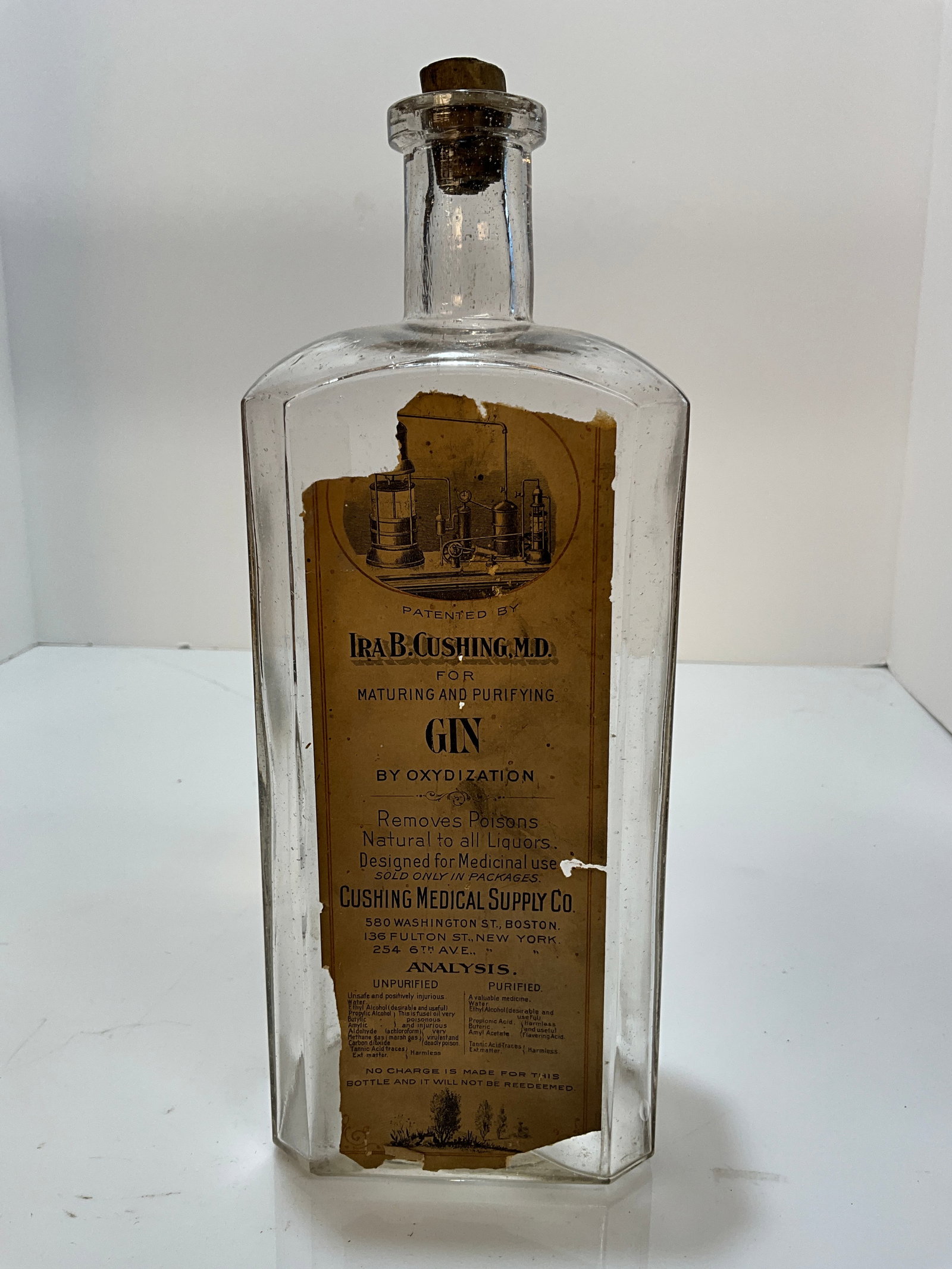 Ira B. Cushing,. M.D. Medical Gin, Cushing Medical Supple Co. Tall Bottle with Label.: Here is an aqua tall Square 10", Ira B. Cushing,. M.D. Medical Gin, Cushing Medical Supple Co. Tall Bottle with Label. During prohibition one of the ways to get liquor was to be prescribed by a Doctor