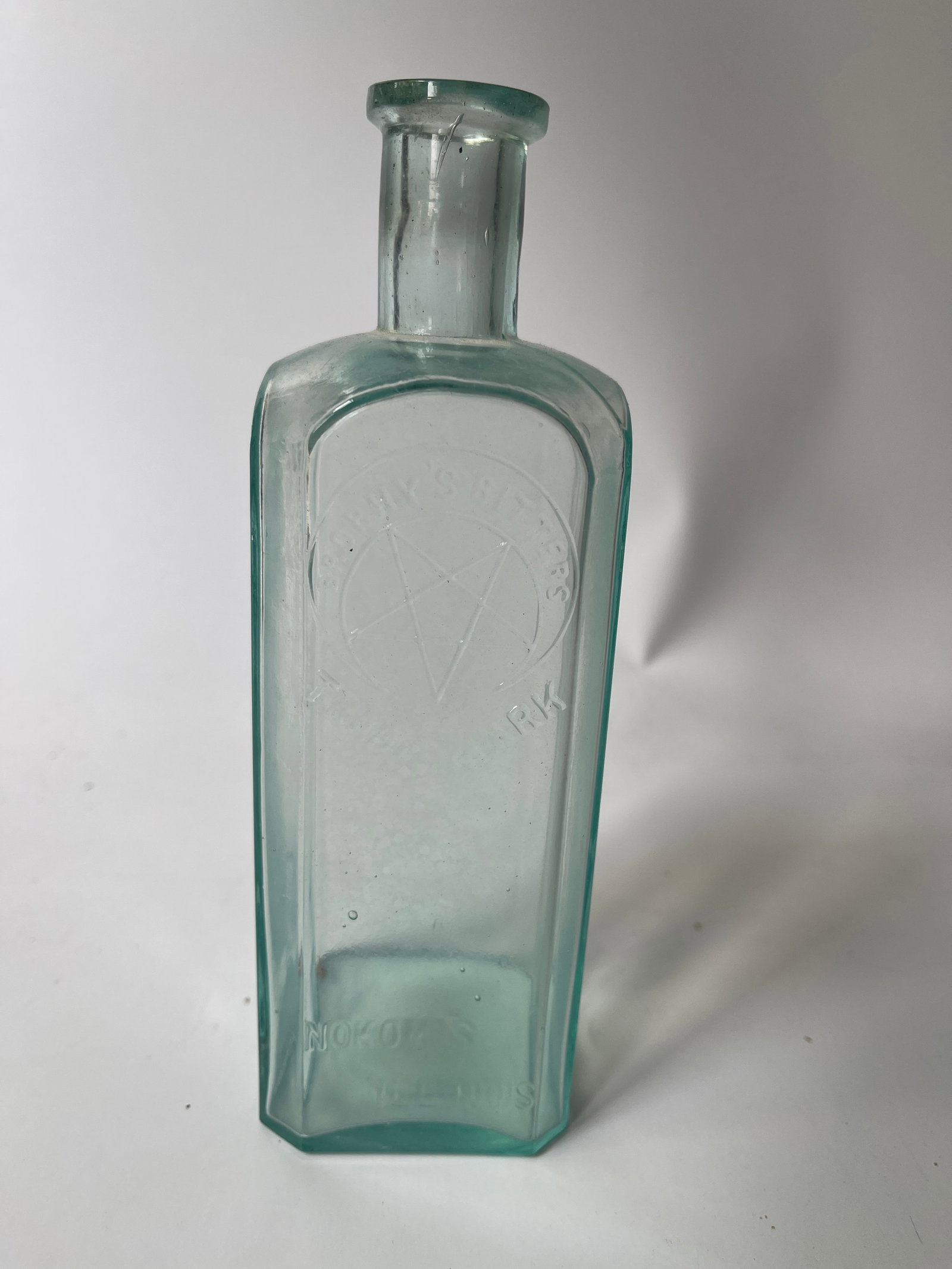 Brophy's Bitters Nokomis, Illinois, aqua square no damage.: Here's an odd Bitters from Illinois. The bottle is embossed Brophy's Bitters Nokomis, Illinois. It also has a embossed moon and star. The bottle has no damage but has internal stain that may was out.