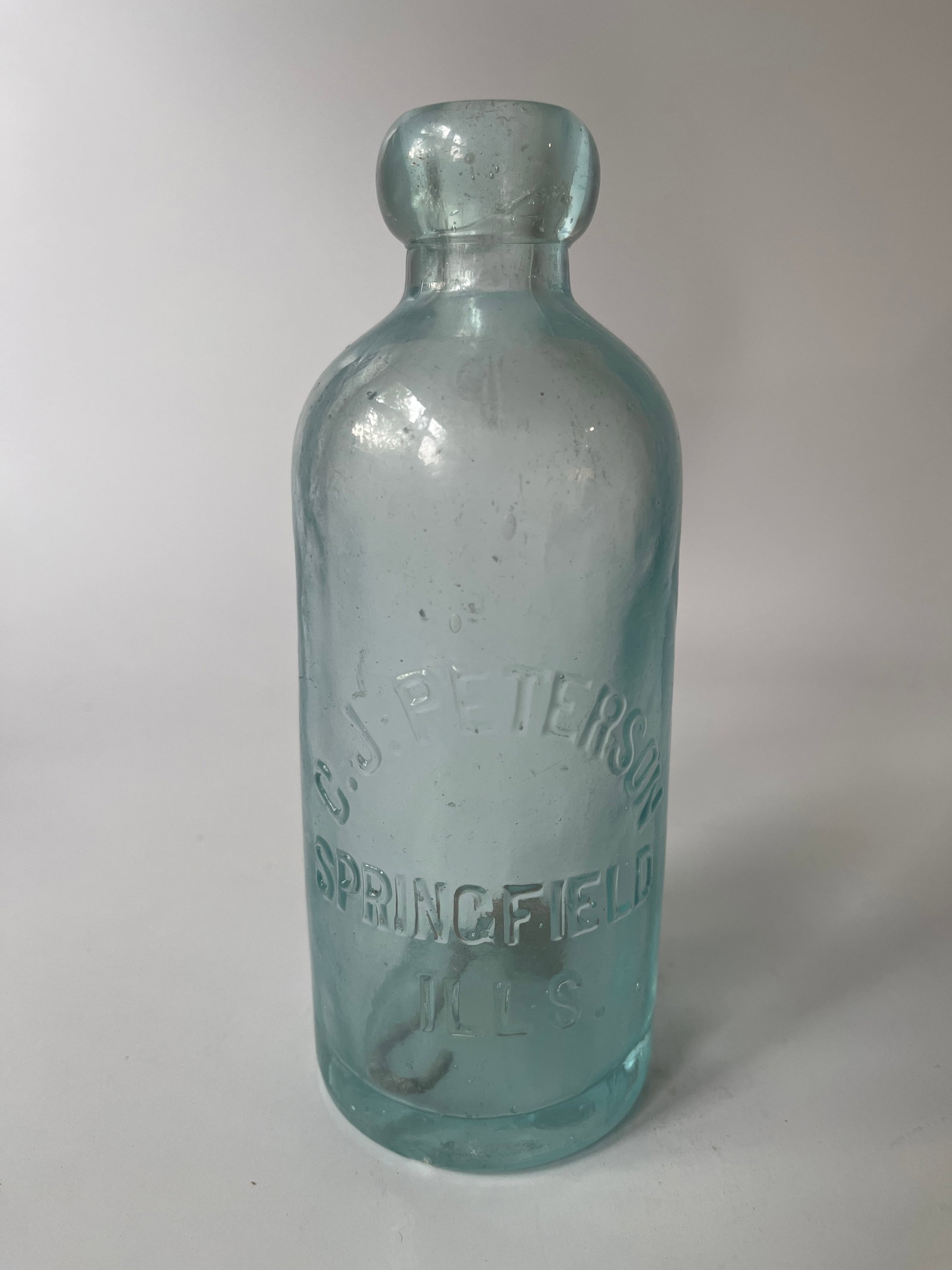 C.J. Peterson Springfield, Ills aqua hutch soda.: Here's aqua C.J. Peterson Springfield, ILLs hutch soda. The bottle has a small chip on the heal, otherwise no damage. It also has overall light haze.
