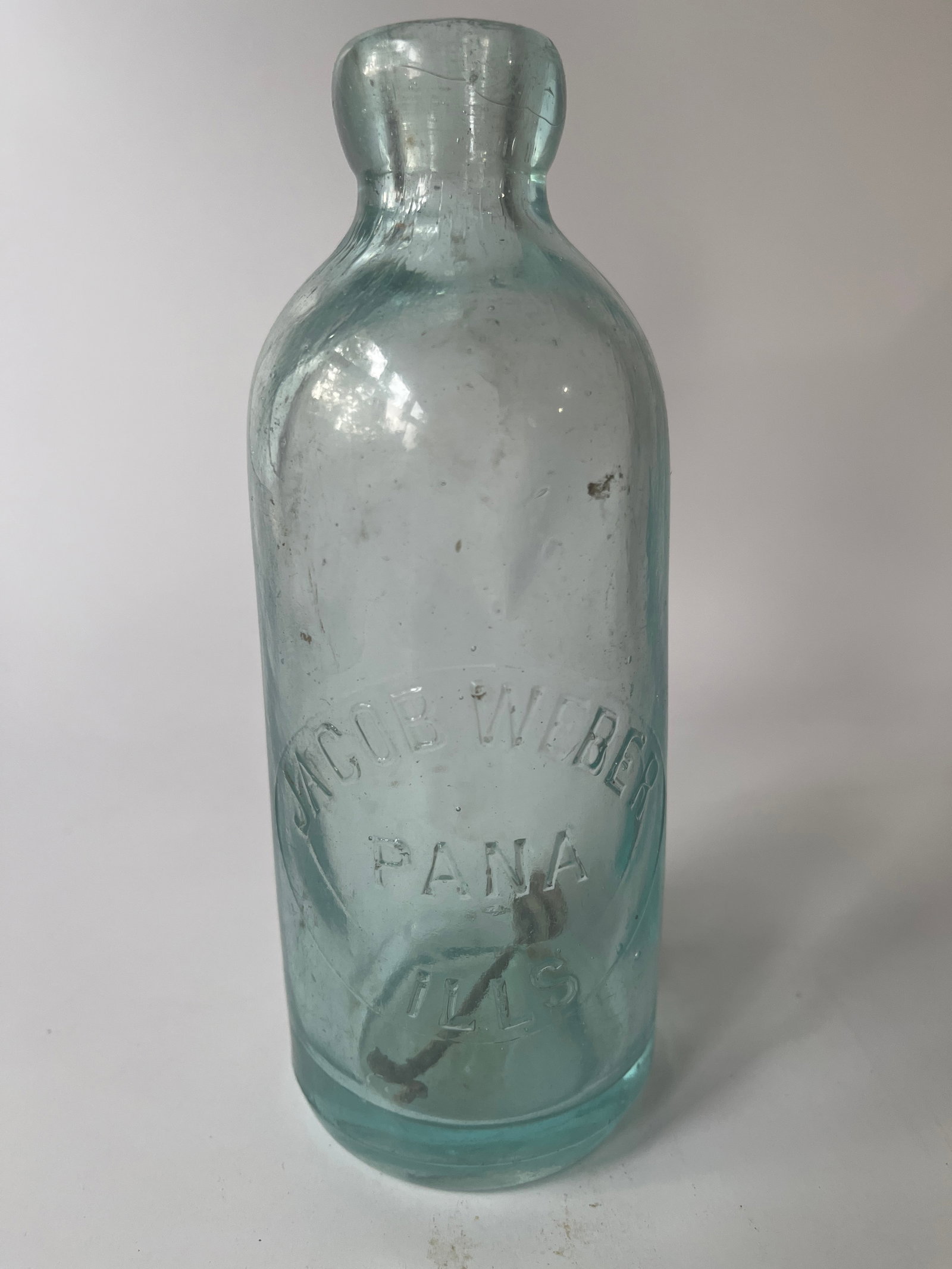 Jacob Weber Pana Ills aqua hutch soda.: Here we have a Jacob Weber Pana Ills hutch soda. The bottle is aqua in color and has no damage. There is a tiny bit of stain.