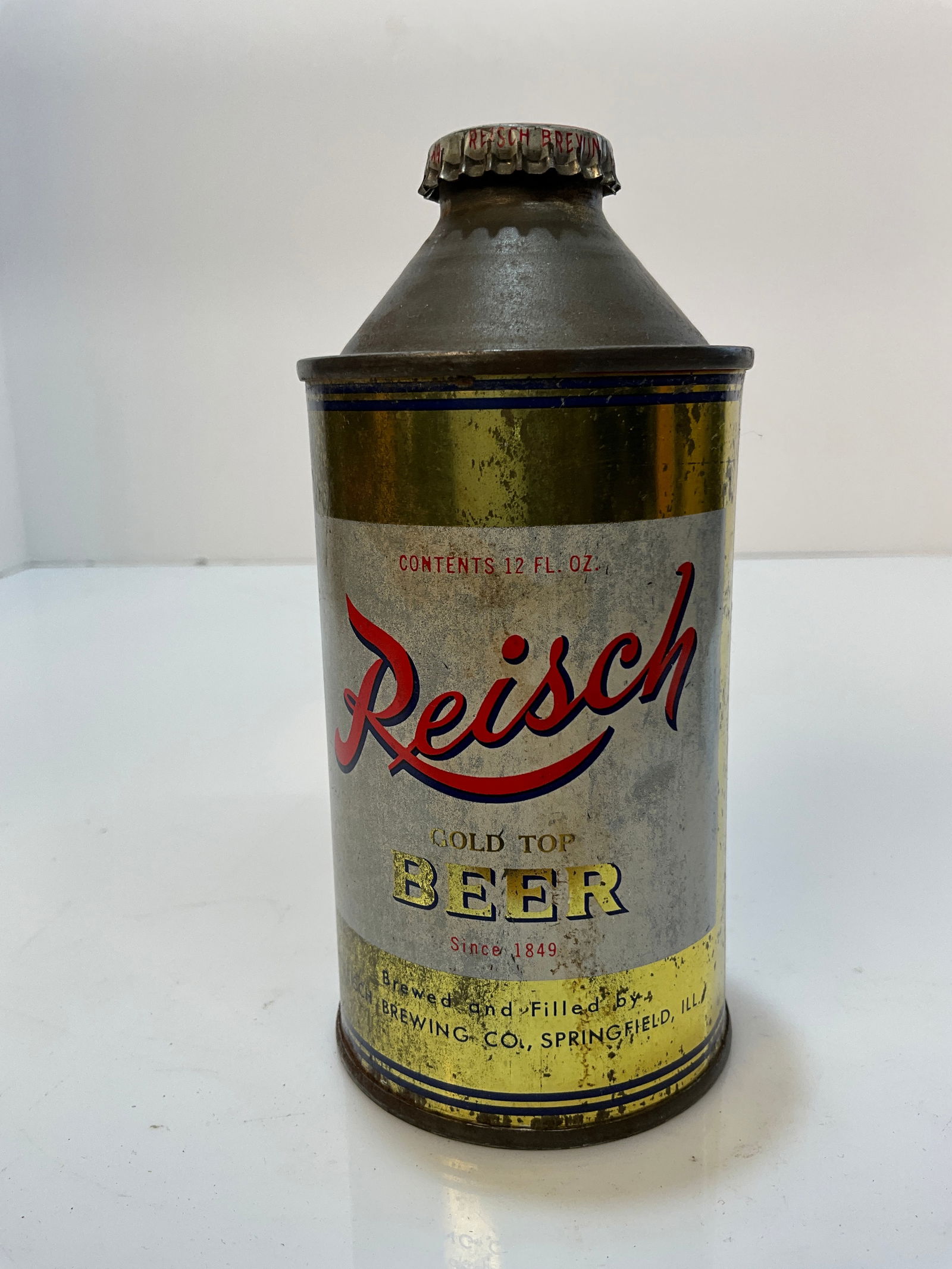 Reisch Beer Gold Top, Cone Top Beer Can, with Original Cap: Reisch Beer Gold Top, Cone Top Beer Can, with Original Cap. A yellow green or green bronze color. Blue lines around the top of the beer can. Neat can with an original cap.