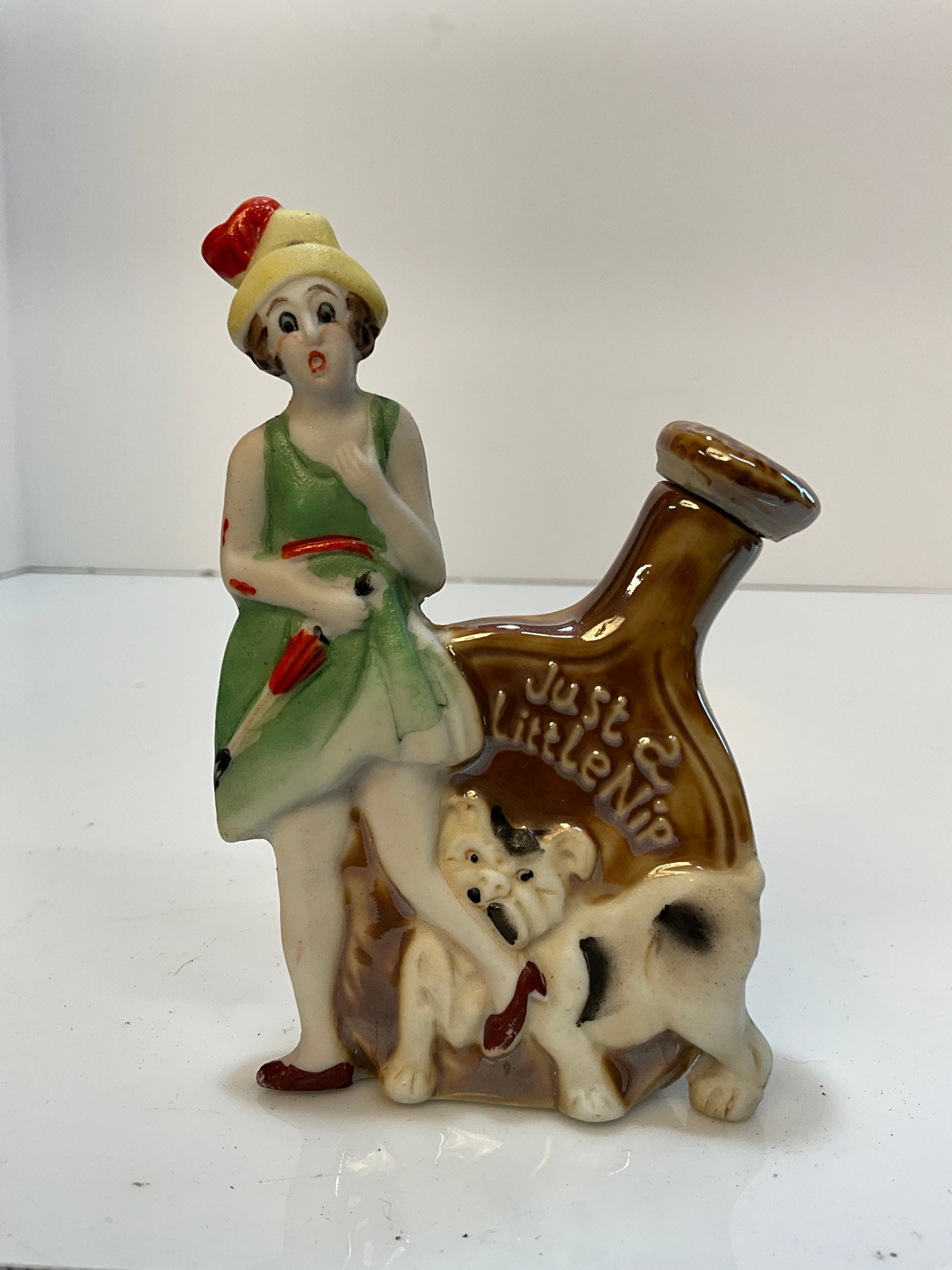 Vintage Whiskey Nip - Flapper Girl with a Dog Biting her Ankle, Advertising Springfield Illinois: Vintage Whiskey Nip - Flapper Girl with a Dog Biting her Ankle - Just a Little Nip - Made in Japan. This one is from Springfield Illinois, a nice and rare advertising piece.