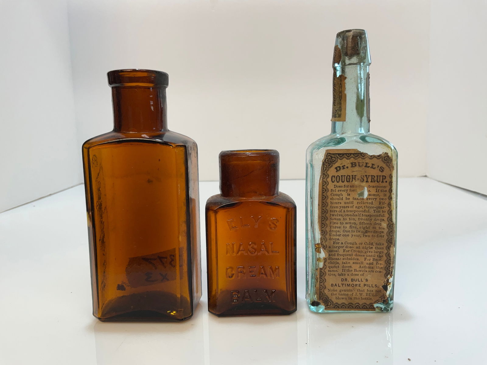Lot of 3 Medicines, Dr Bulls with Full Label Cough Syrup, Ely's & an amber bottle: Lot of 3 Medicines, Dr Bulls Cough Syrup with Full Label, Ely's Basel Cream and one Amber Bottle with the side embossing - Epelepitcide.